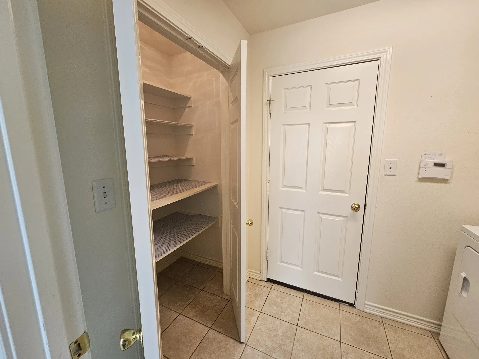 Built-in wood-finish cabinetry provides storage above laundry appliances