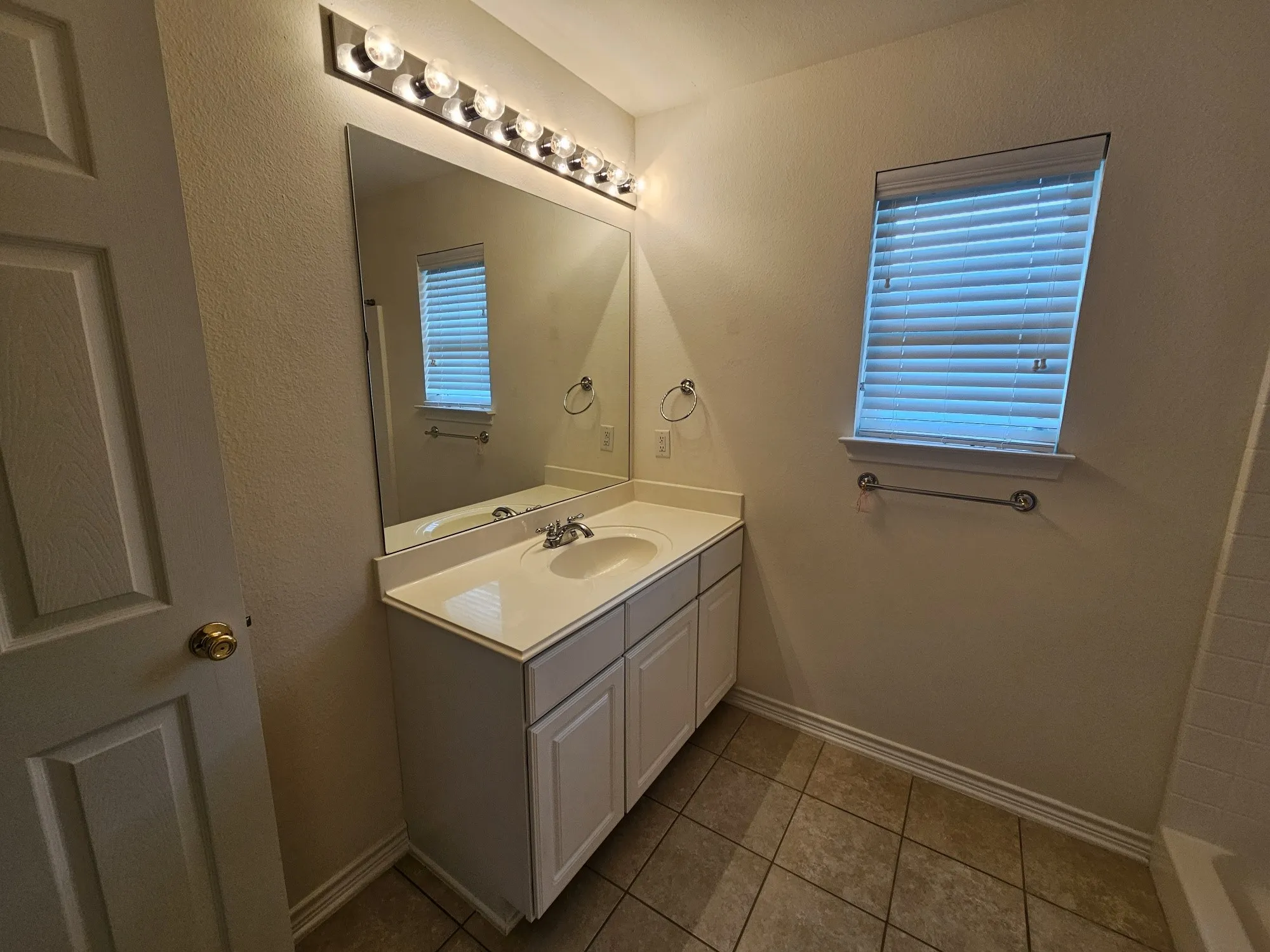 Bathroom vanity with a single basin sink and chrome faucet