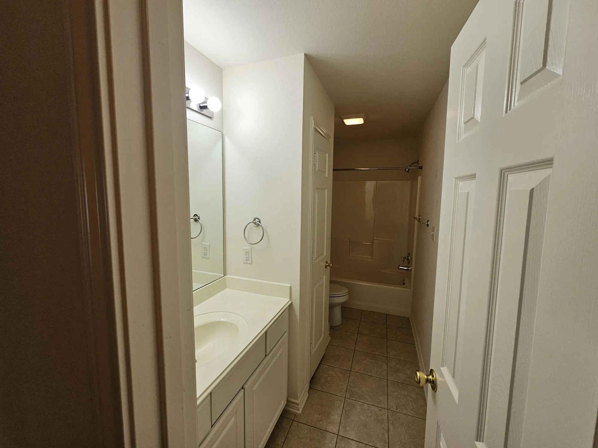 White paneled vanity with an integrated sink, polished chrome hardware, and a framed mirror