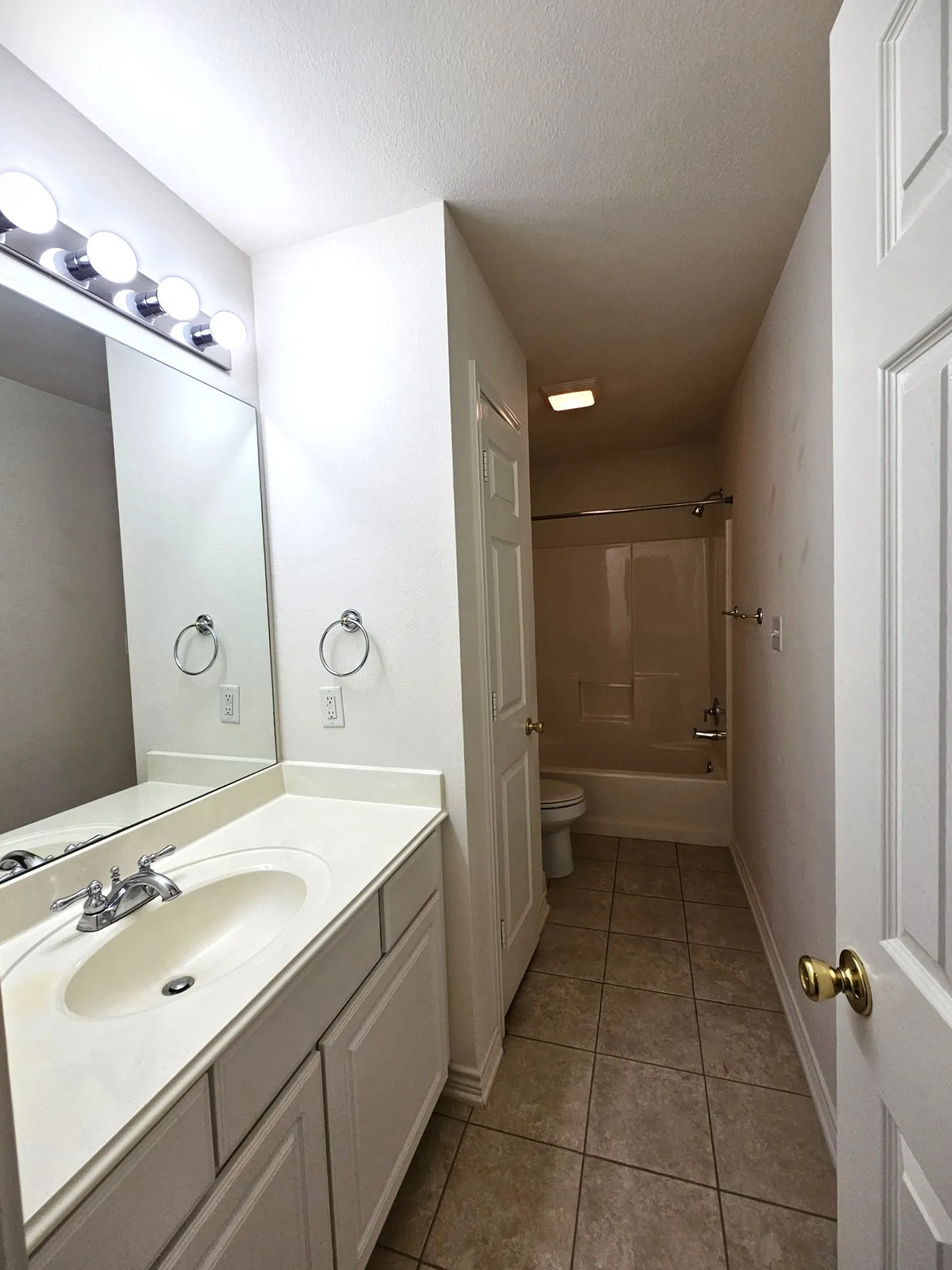 Vanity with an integrated sink, polished chrome faucet, and storage cabinetry