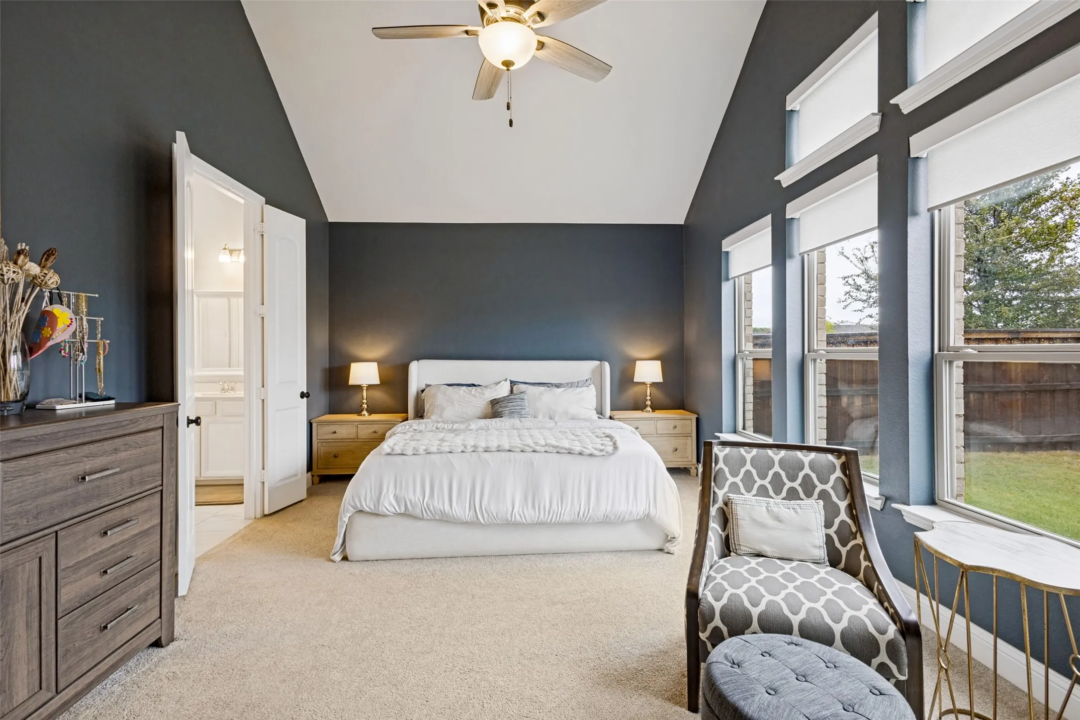 primary with large windows outlooking backyard. Large high ceilings