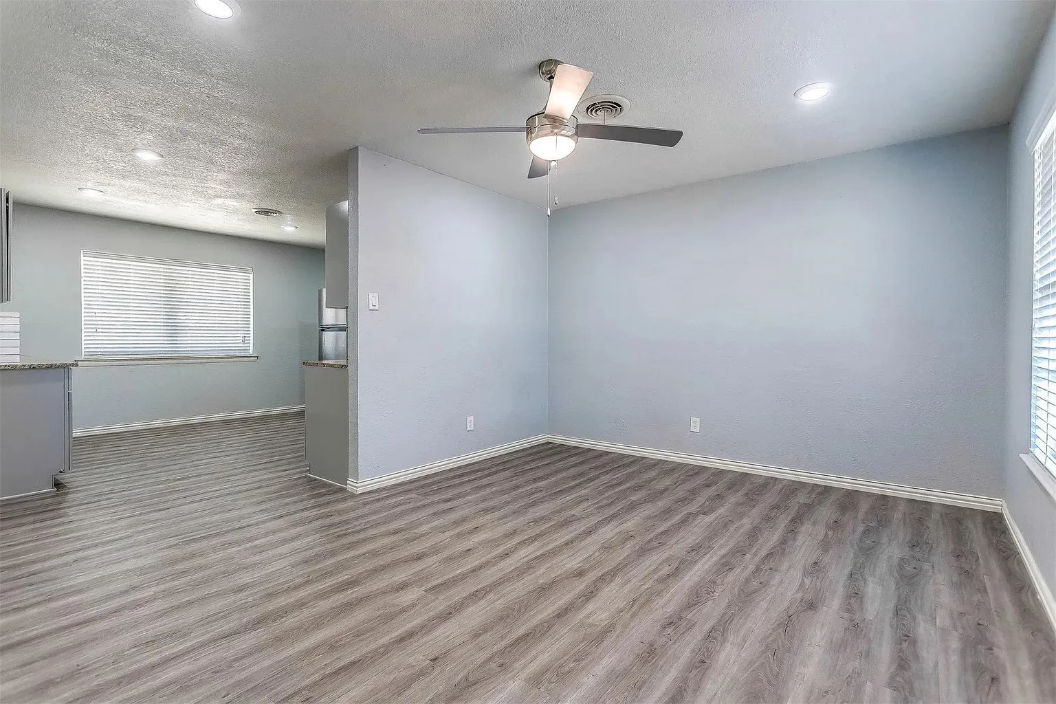 Wood-finish flooring throughout, recessed lighting, and a ceiling fan with integrated light