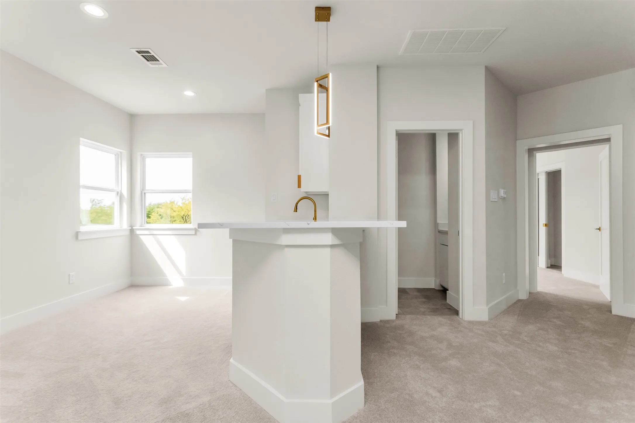 Built-in counter with a light-toned surface, recessed lighting, and a modern pendant​​‌​​​​‌​​‌‌​‌‌​​​‌‌​‌​‌​‌​​​‌​​ fixture