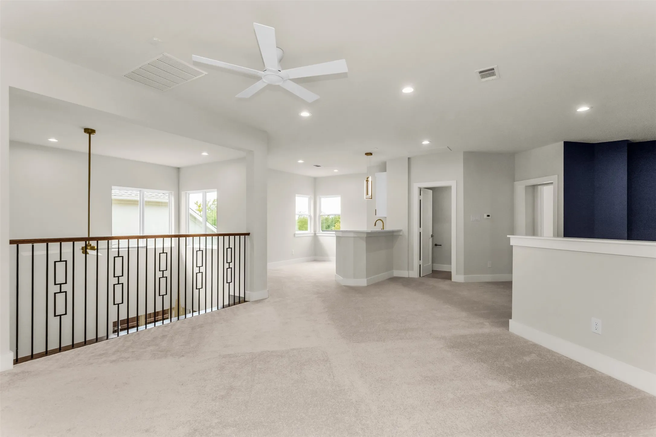 Open concept space with neutral carpet, recessed lighting, and a contemporary ceiling fan