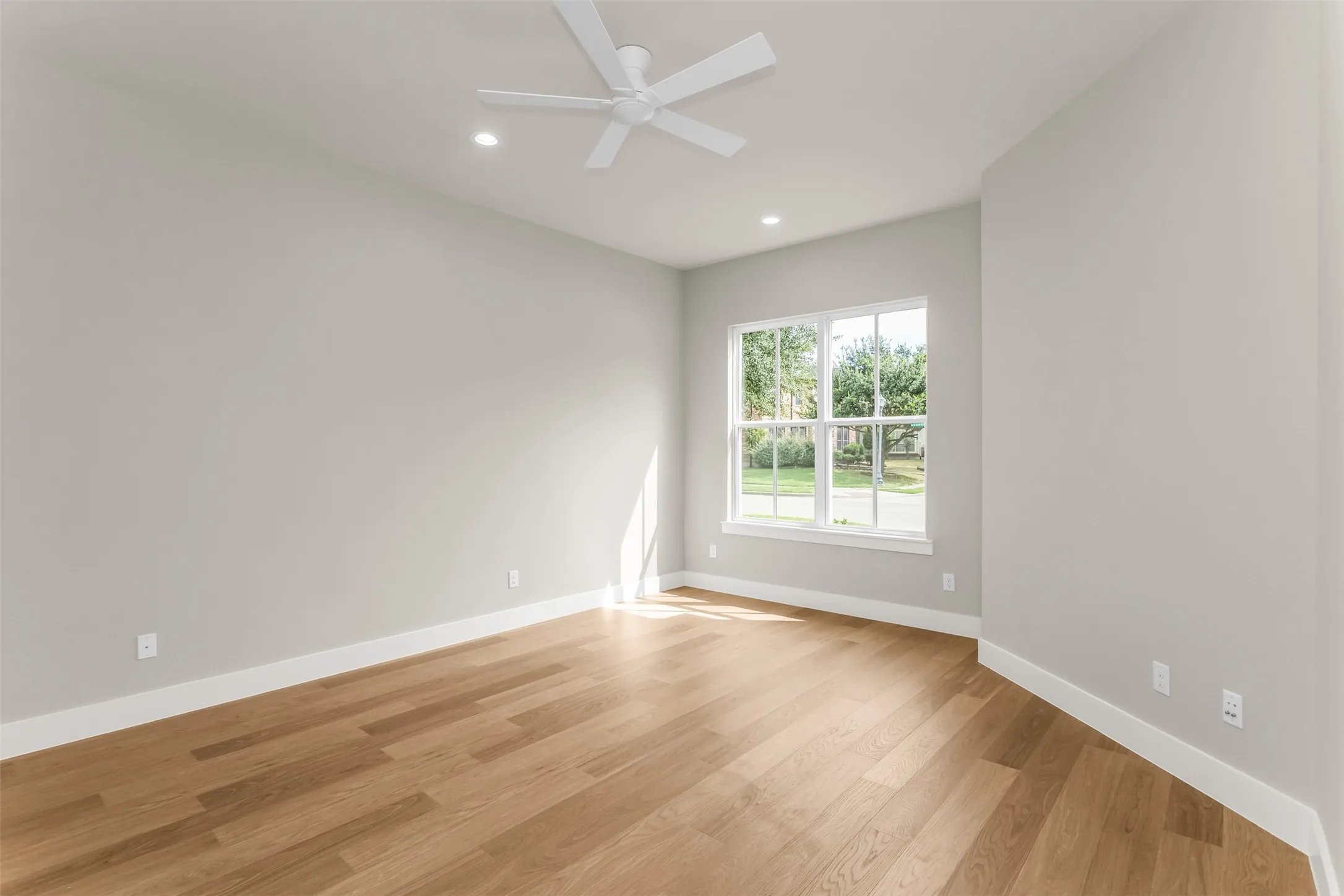 Wood-finish flooring, white trim, recessed lighting, and a ceiling fan