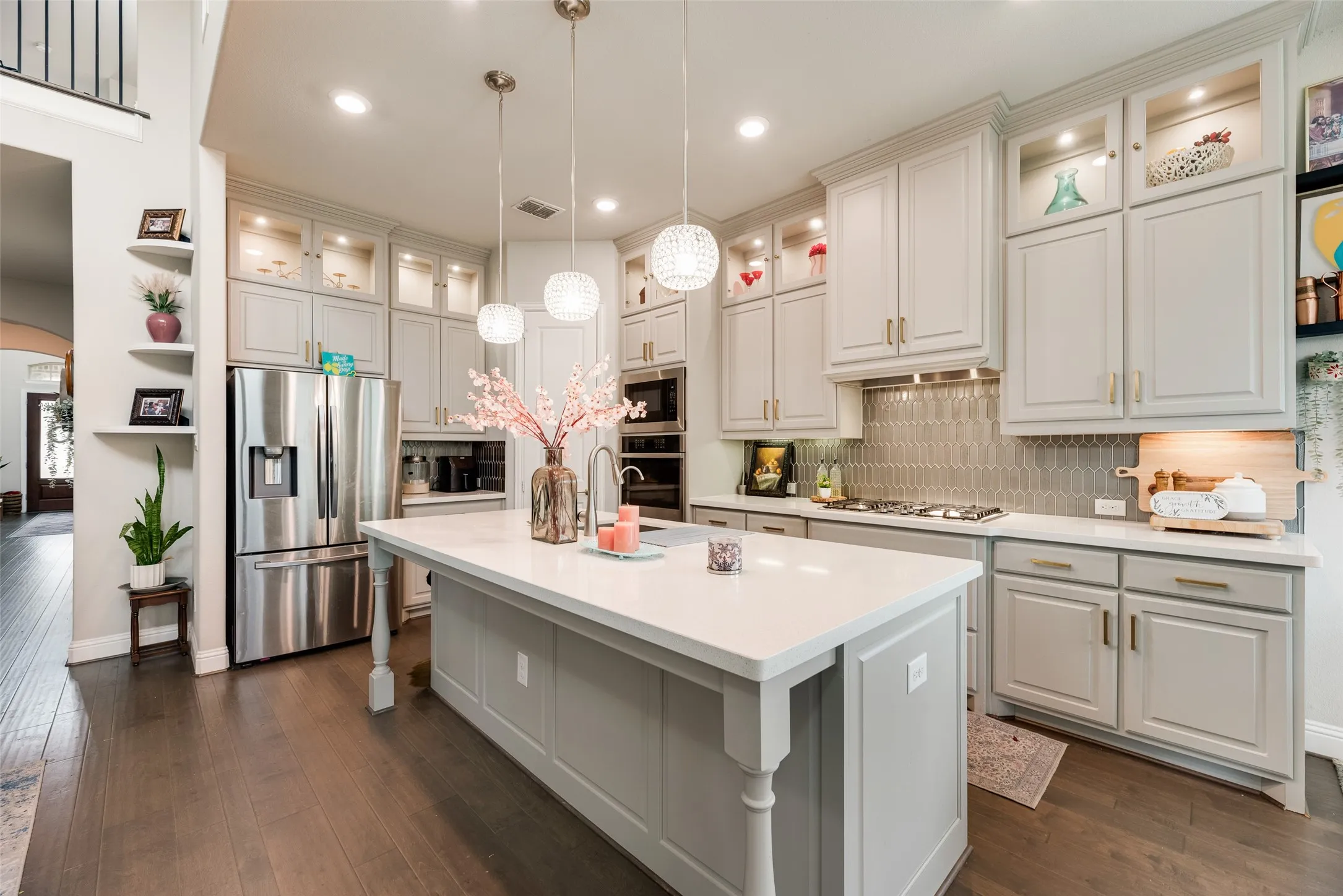Kitchen featuring a large island, wood-finish flooring, recessed lighting, light-toned cabinetry, and stainless steel appliances