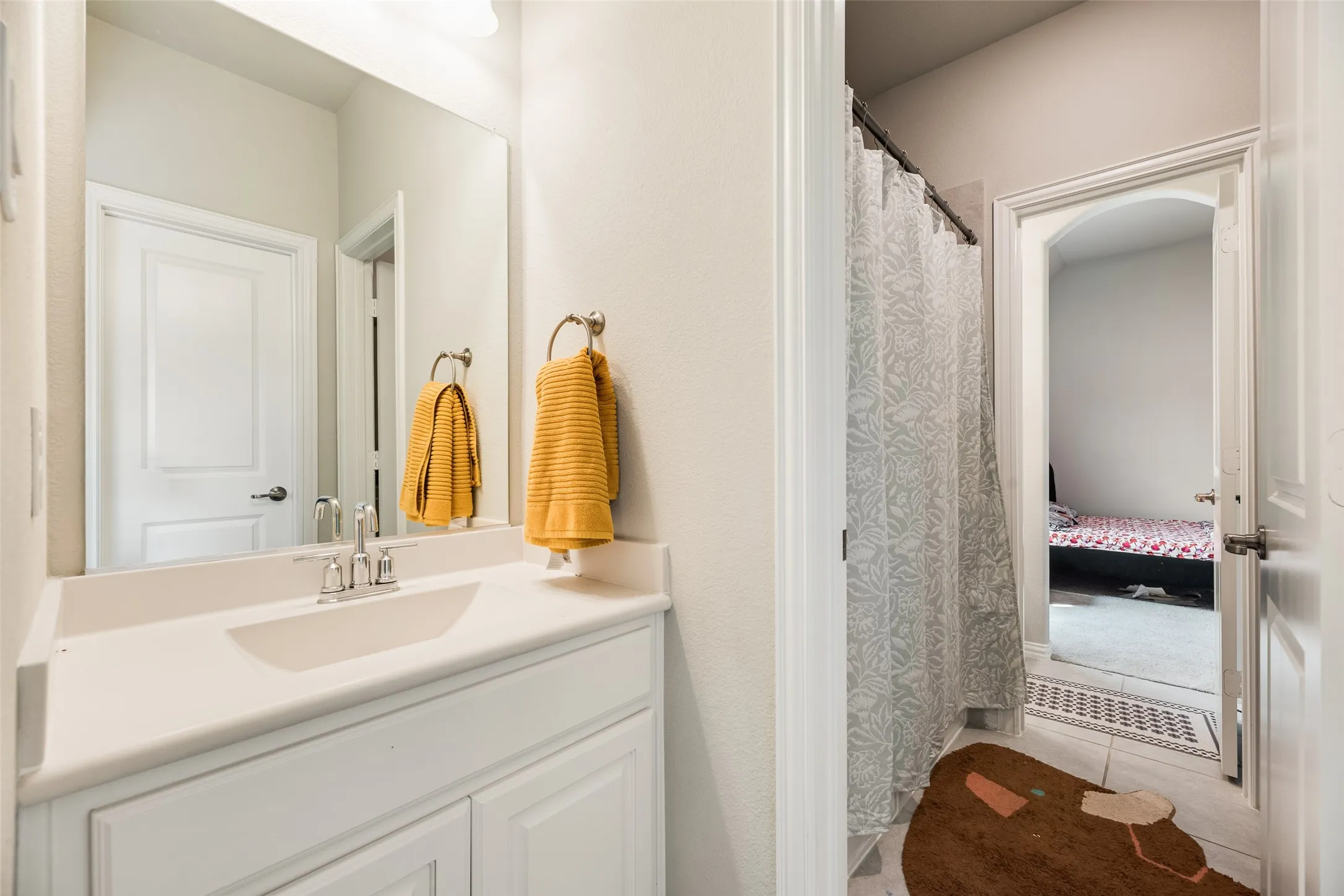 White vanity with shaker-style cabinetry, an integrated sink, and a chrome faucet