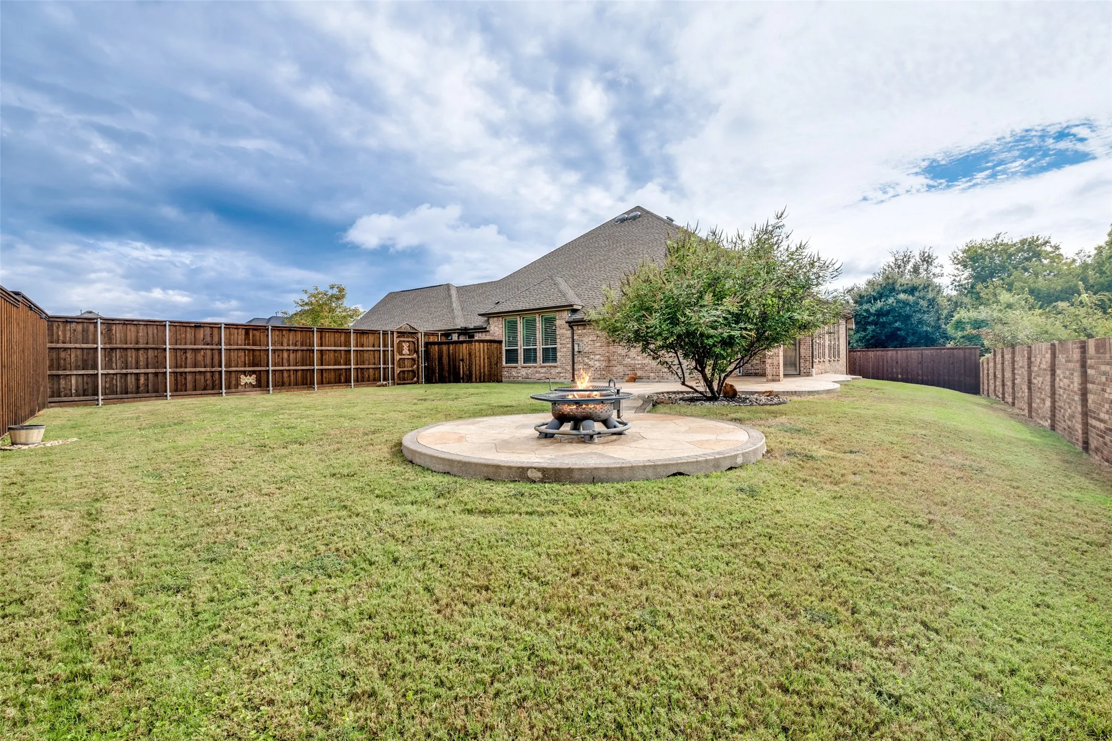Huge back yard with stamped concrete area perfect for a fire pit