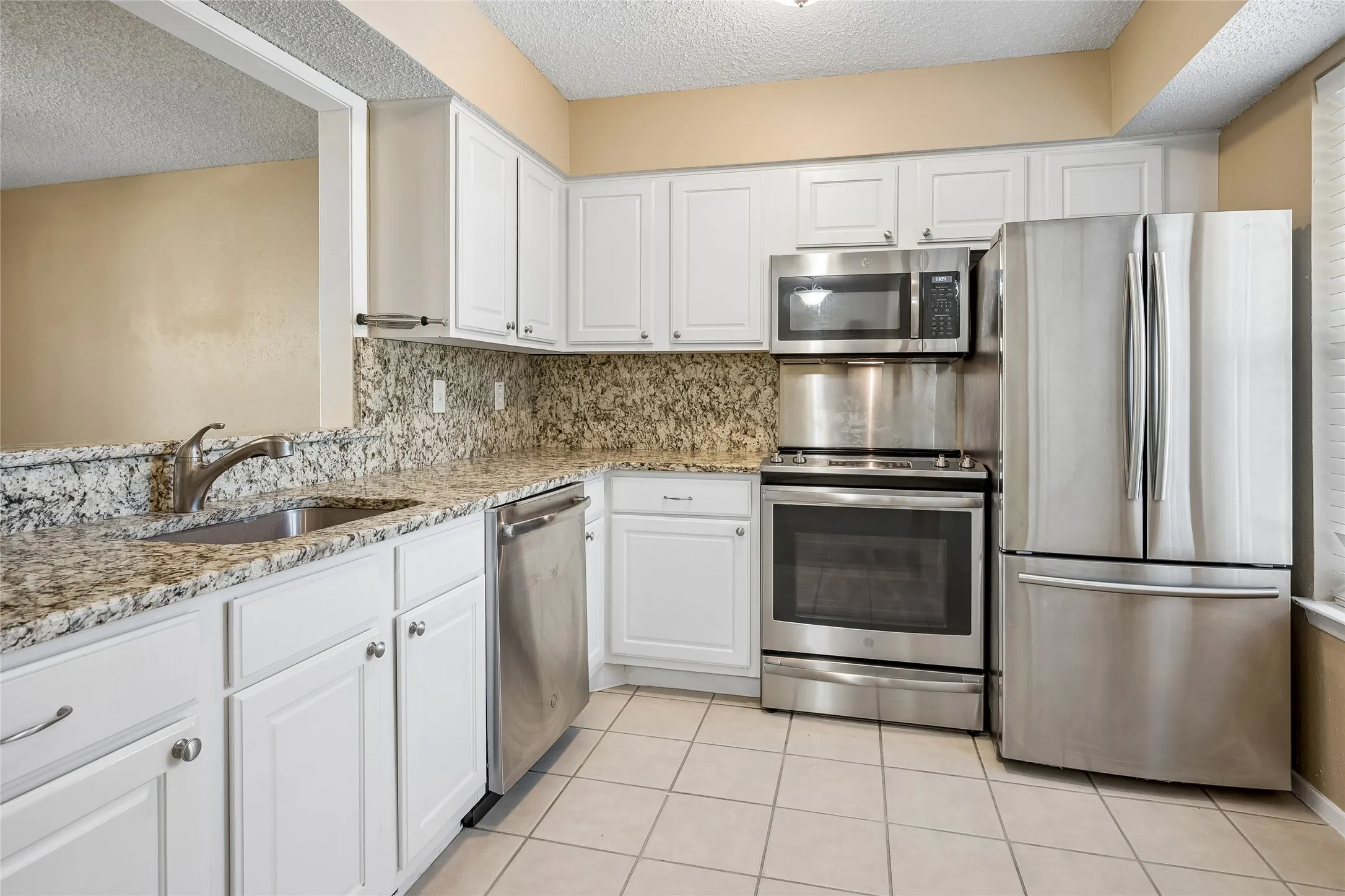 Kitchen with stainless stove and refrigerator