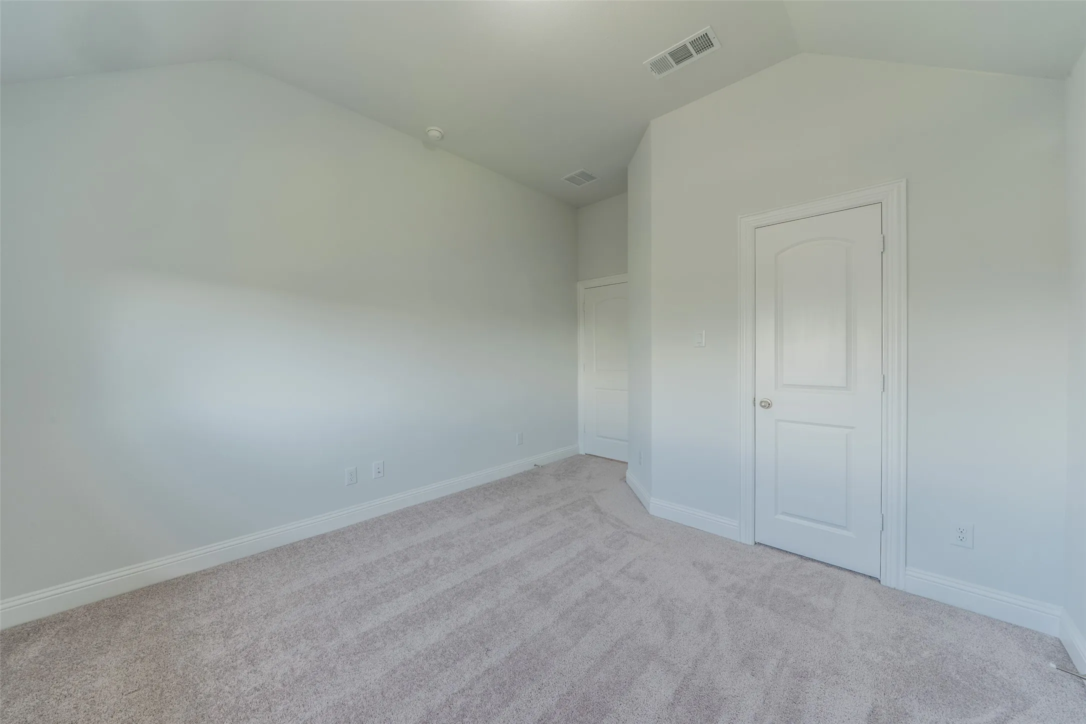 Neutral carpeting, white trim, and white painted walls