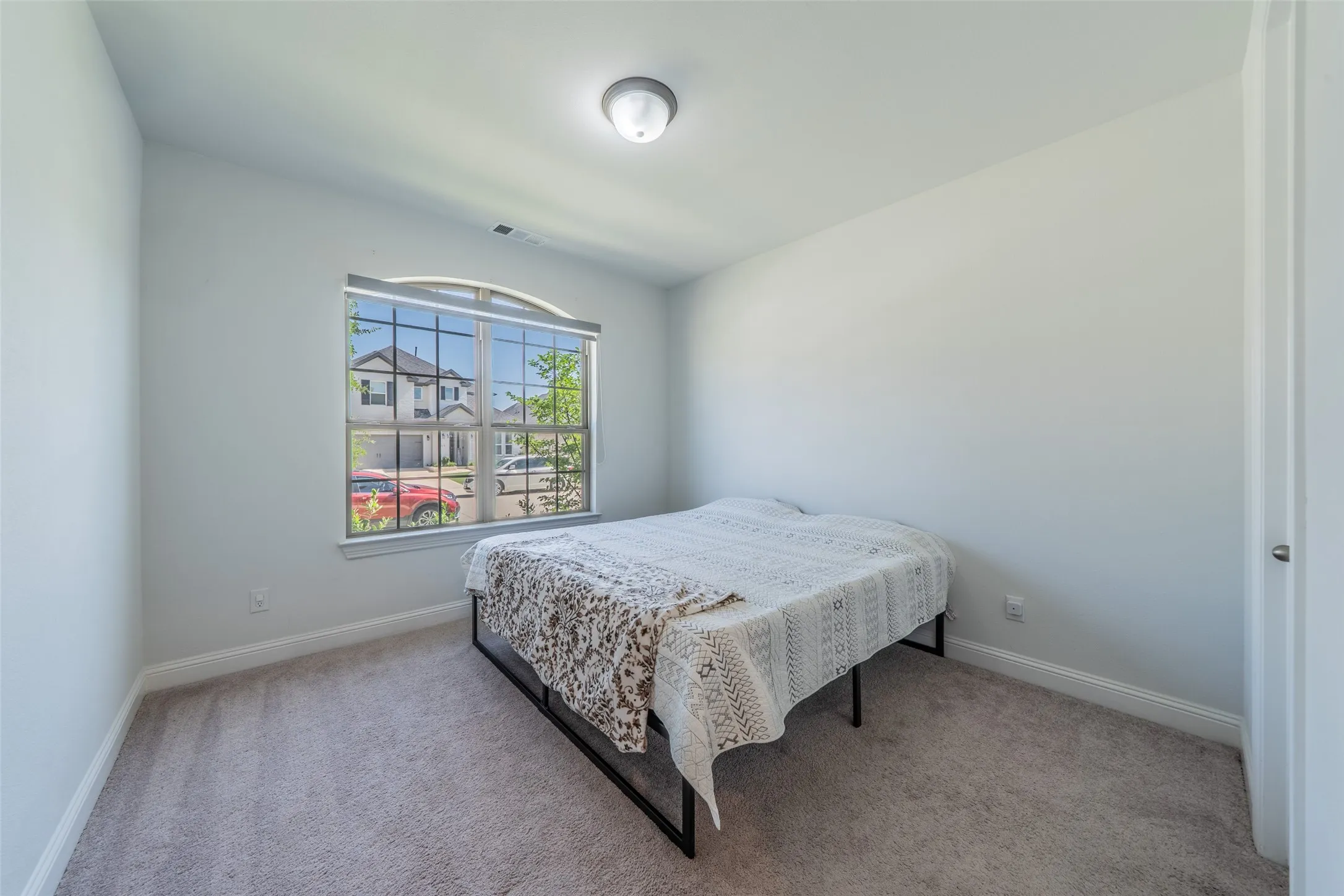 Carpeted flooring, arched window, recessed lighting, and a white interior door