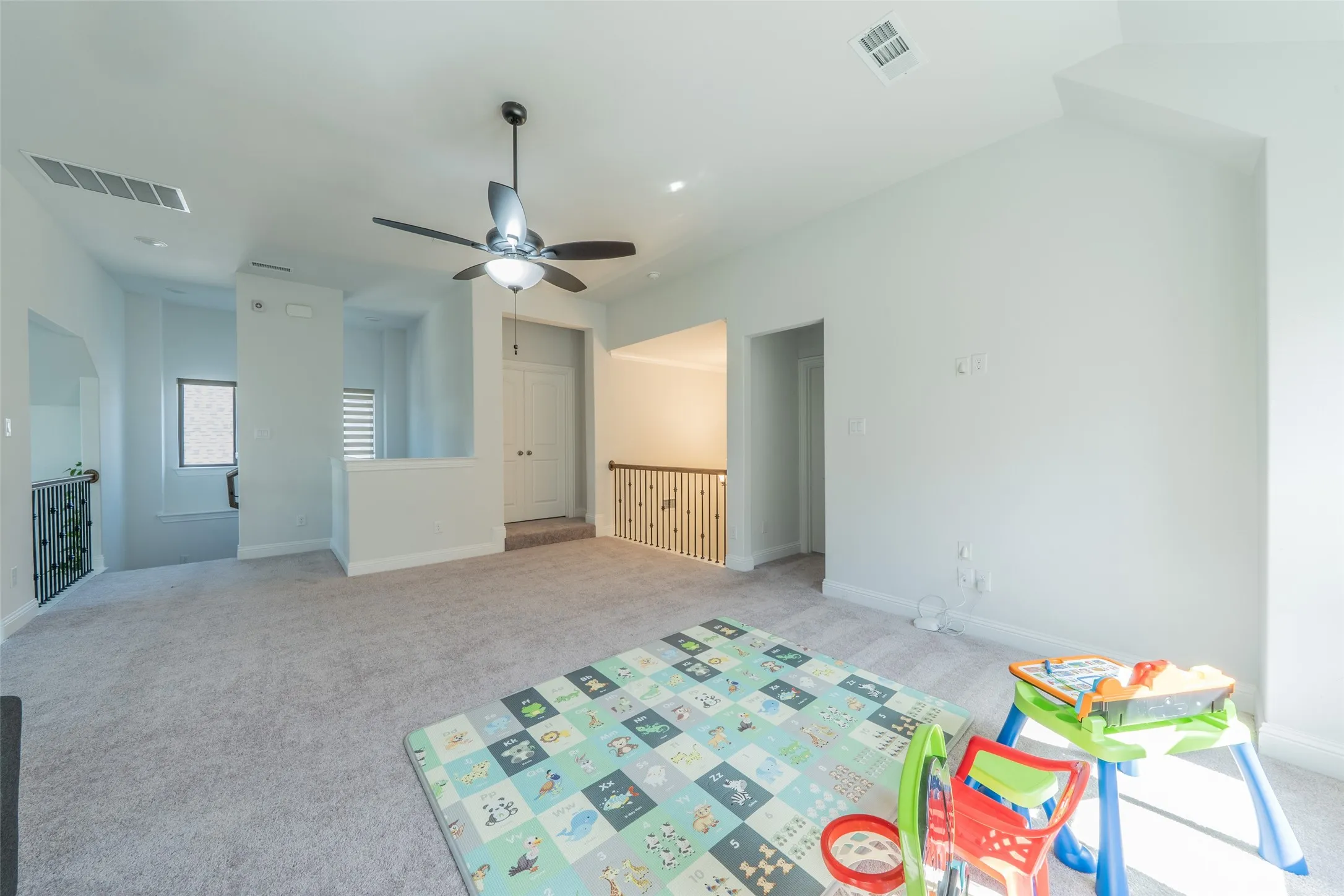 Carpeted upper-level space featuring a ceiling fan, recessed lighting, white painted walls, and a built-in closet with double doors