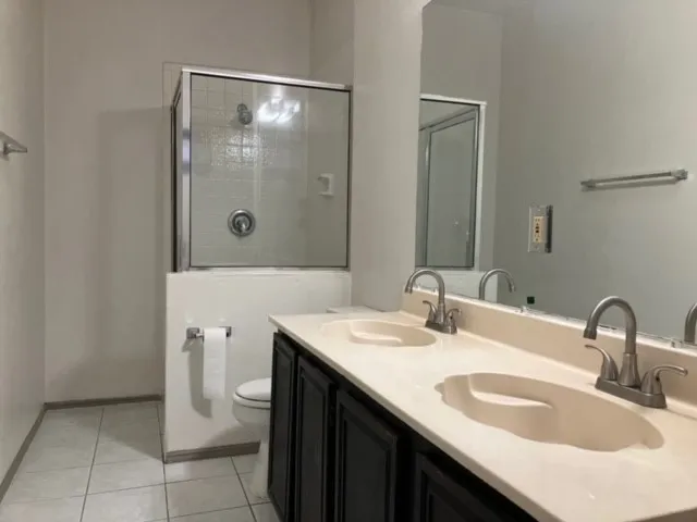 Dual vanity with integrated sinks, brushed nickel faucets, and a dark wood-finish cabinet