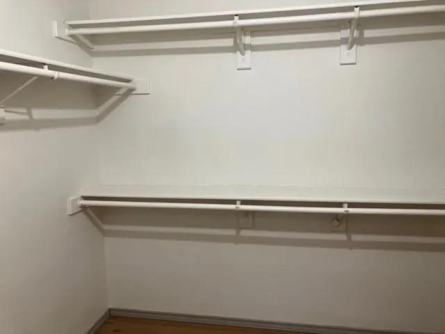 White walls featuring built-in shelving and hanging rods