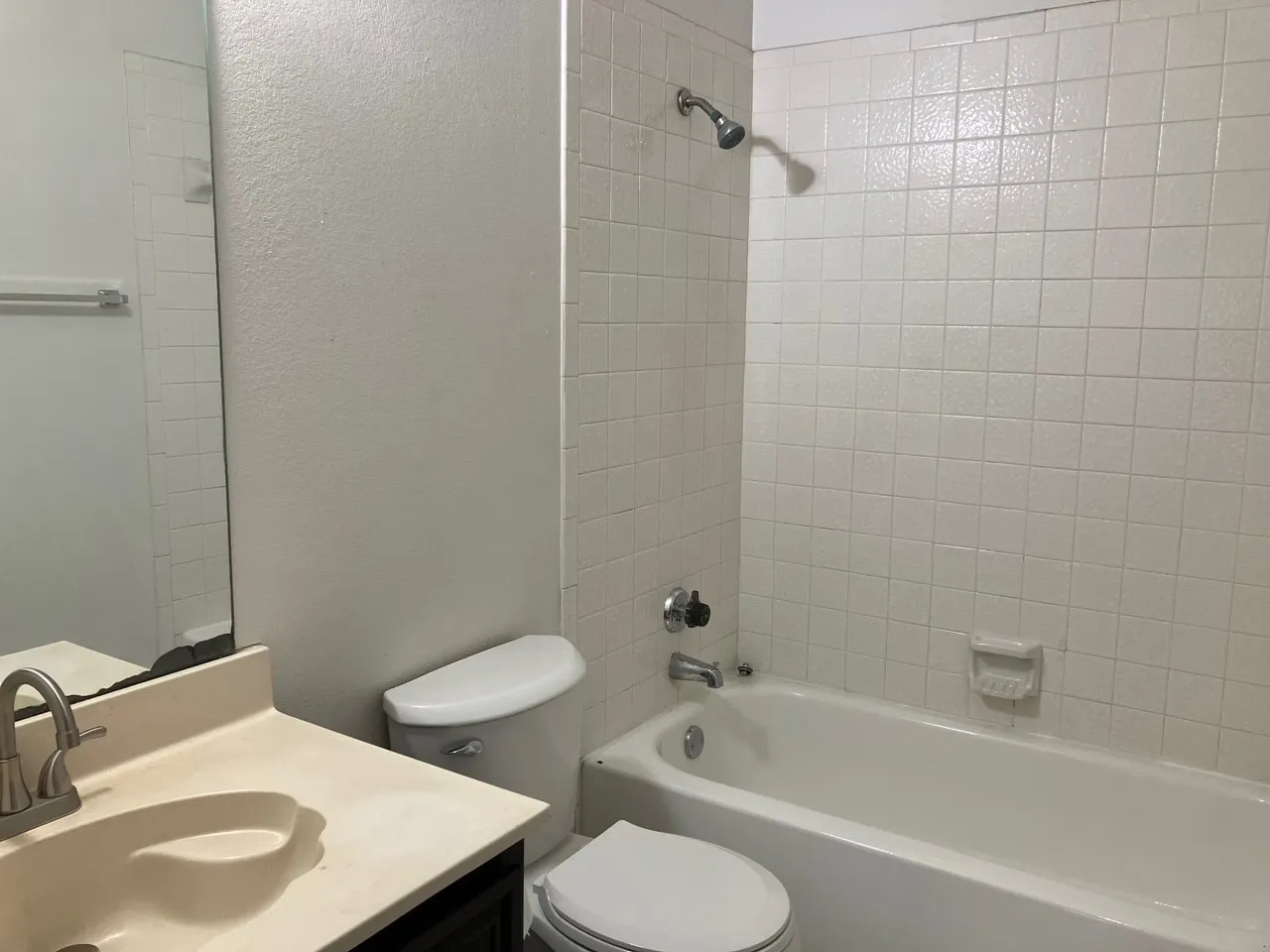 Built-in vanity with an integrated sink, brushed nickel faucet, and a wall-mounted mirror