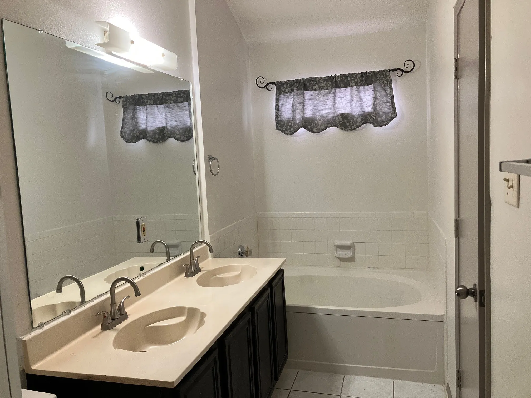 Dual vanity with integrated sinks, brushed nickel faucets, and dark wood-finish cabinetry