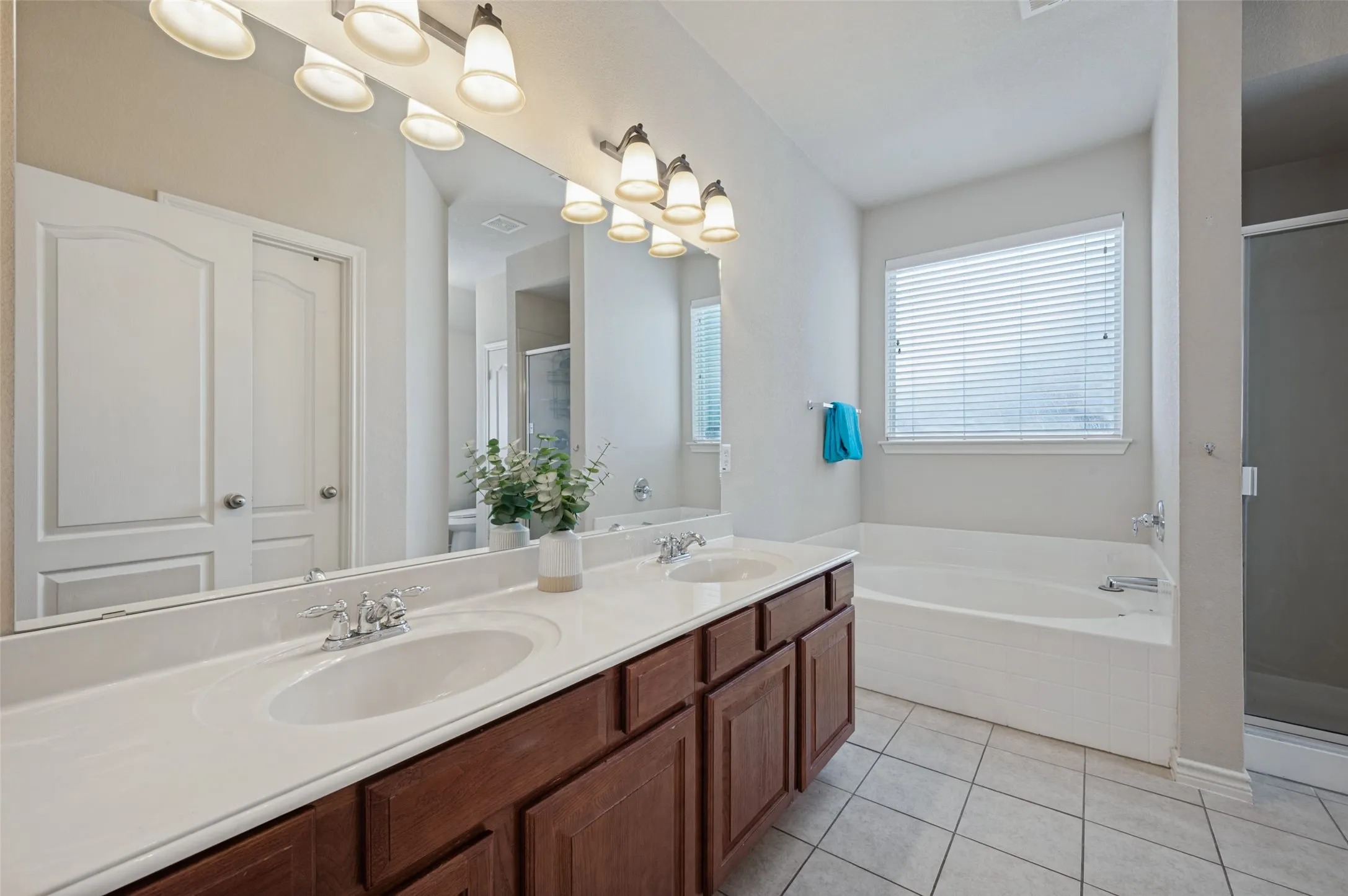 Double sink and ample of counter space and you cant miss yourself in this oversized mirror , large sit bath with natural lighting, in case you do not want to dip in a bath, walk into your shower and be and out.