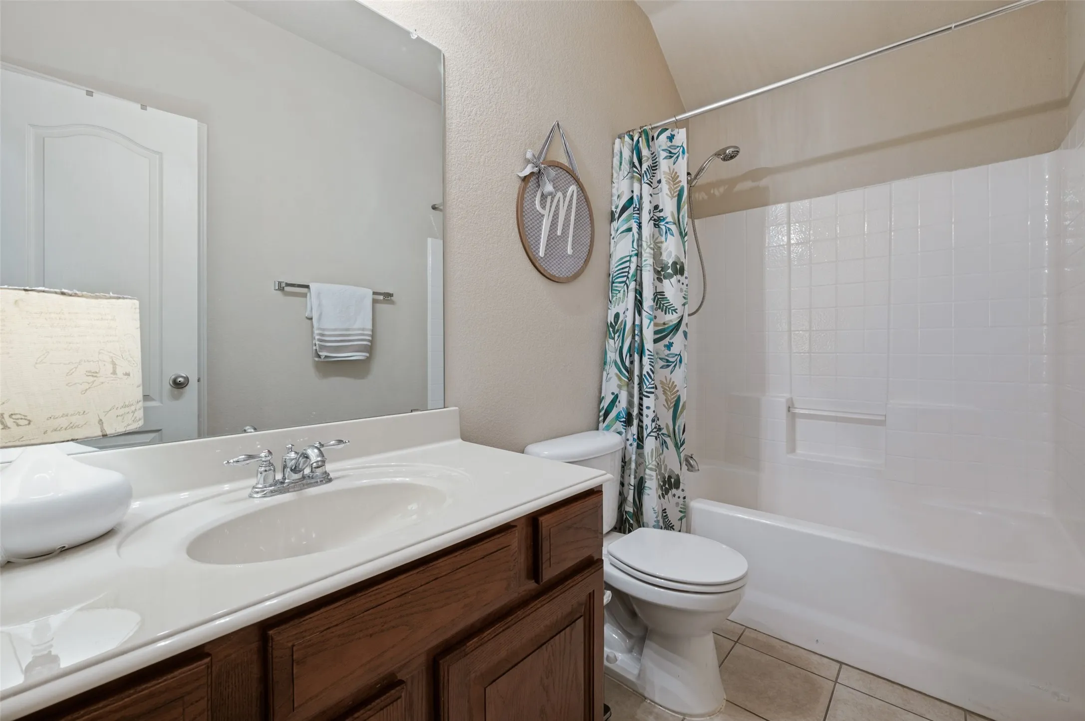 Secondary full bath downstairs that is shared by bedroom 1 and 2. Large vanity and counter space