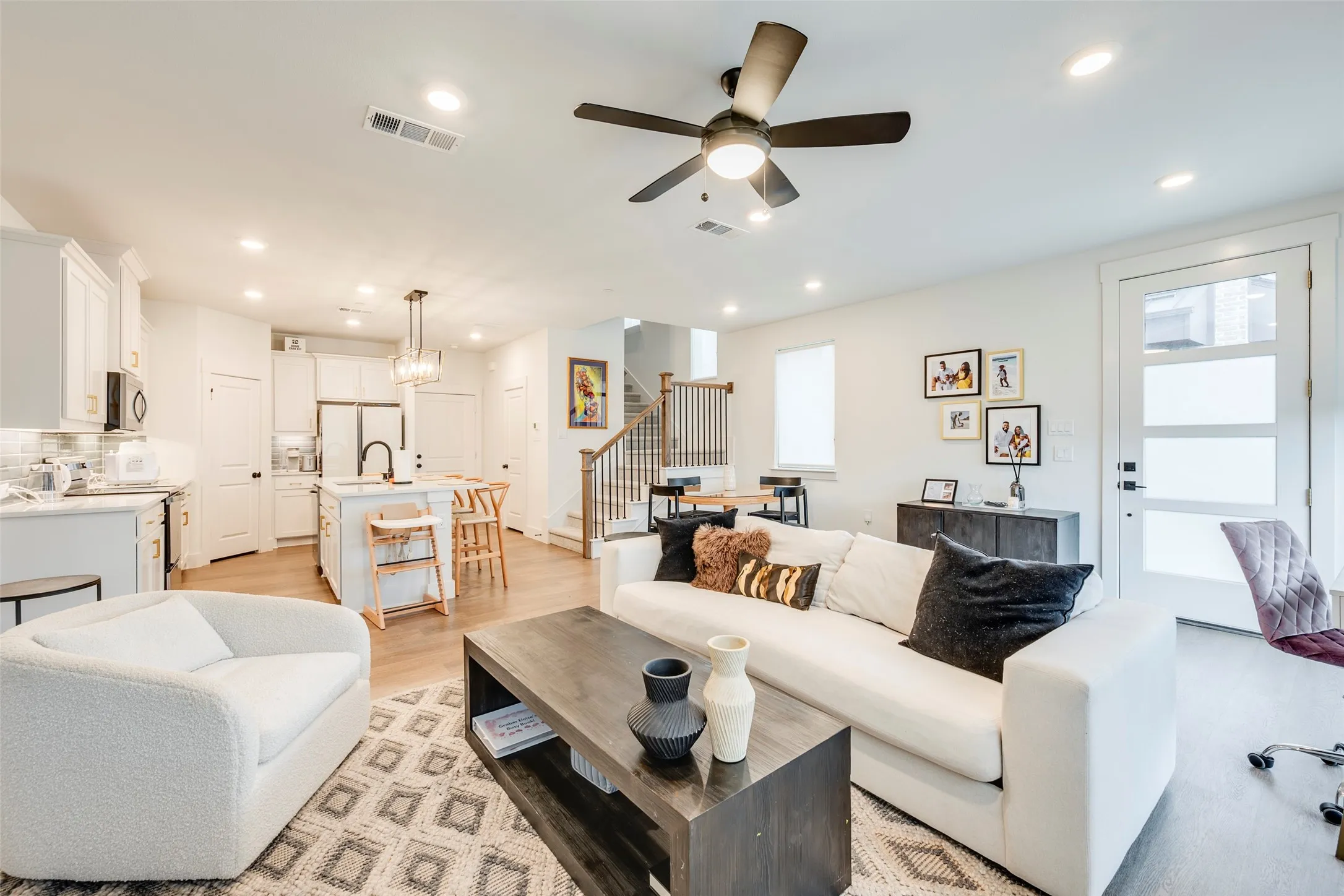 Open-concept living area with wood-finish flooring, recessed lighting, and a ceiling fan
