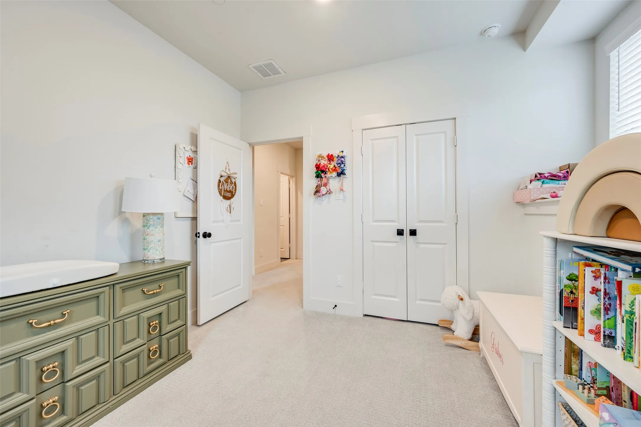 Soft neutral carpeting, white interior walls, white paneled doors with black hardware, and white window blinds