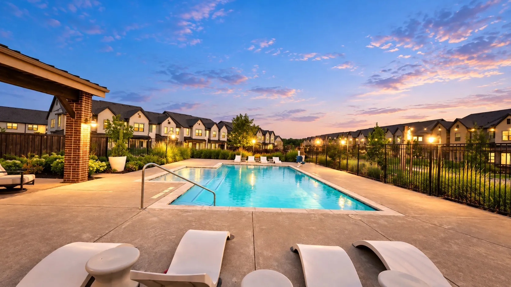 Rectangular swimming pool with integrated steps, concrete pool deck, and a brick-columned pergola with exposed beams