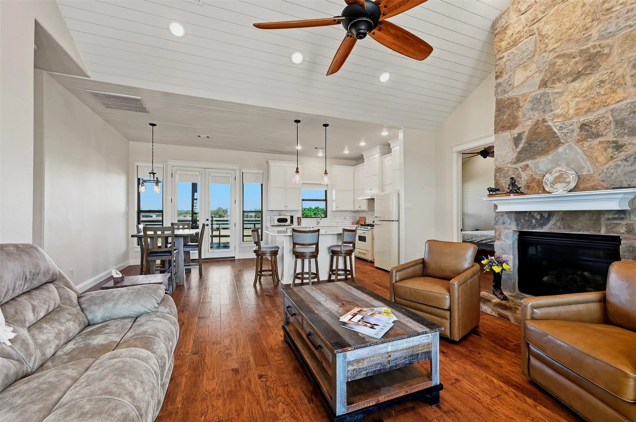 Living area with open floor plan to adjoining kitchen and dining area.