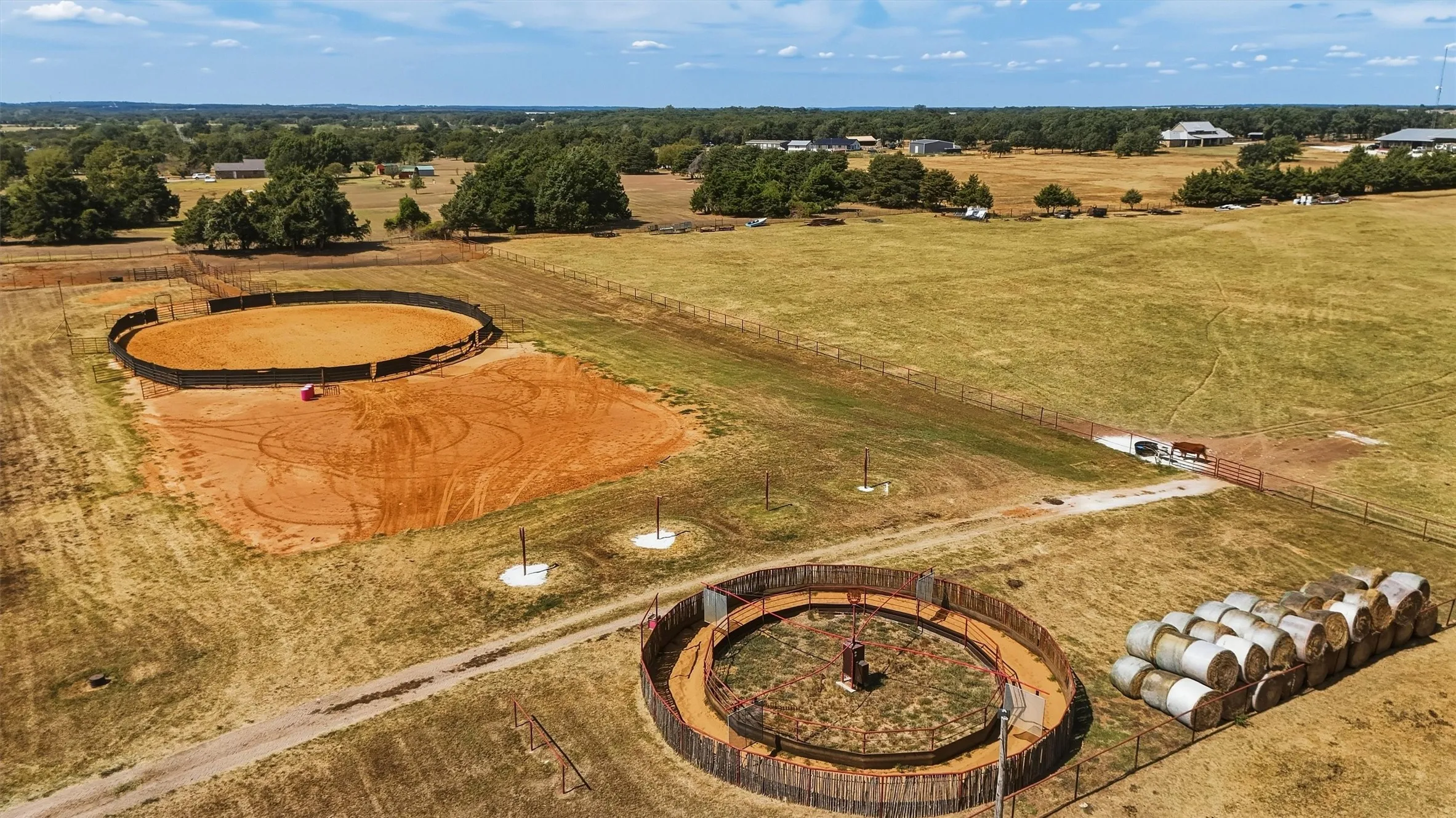 Outdoor round pen, track and outdoor horse walker behind the arena.