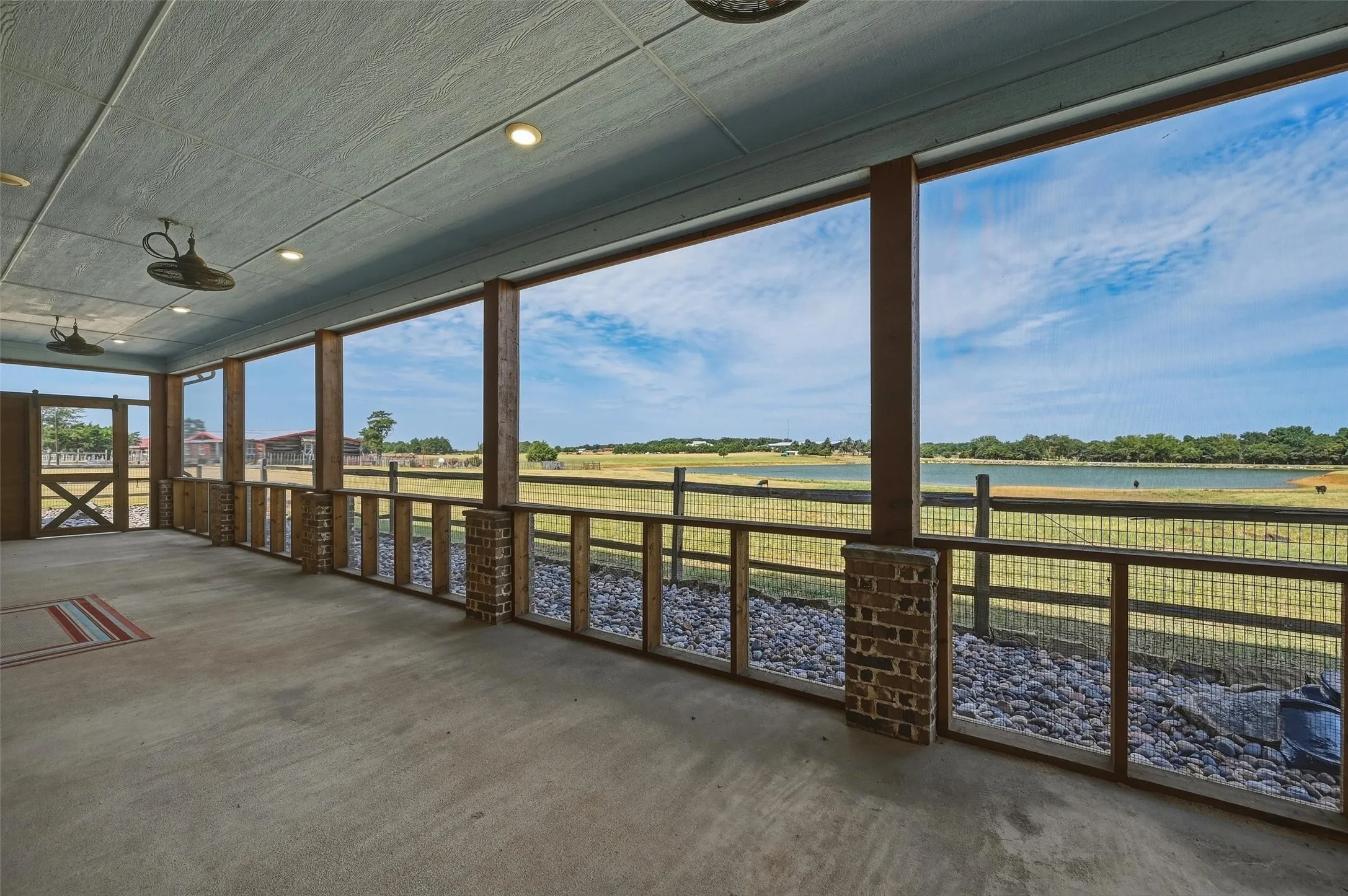 Covered back patio runs the full length of the house with a view of the back pond and pastures.