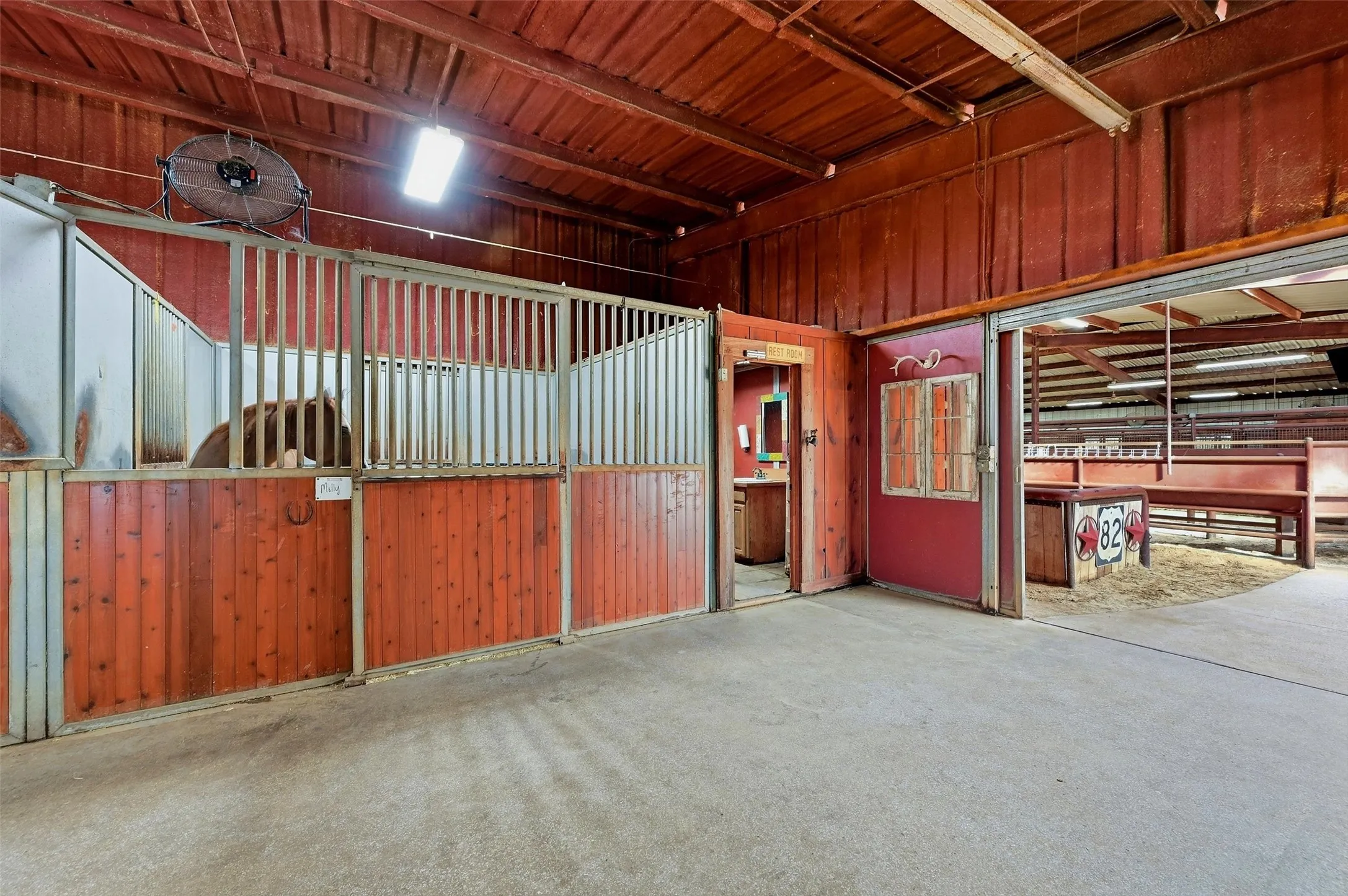 Barn stalls, bathroom and entrance to the covered arena.