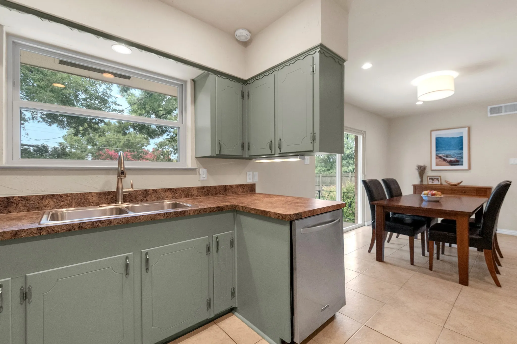 Kitchen with sage green cabinetry and a dual basin stainless steel sink