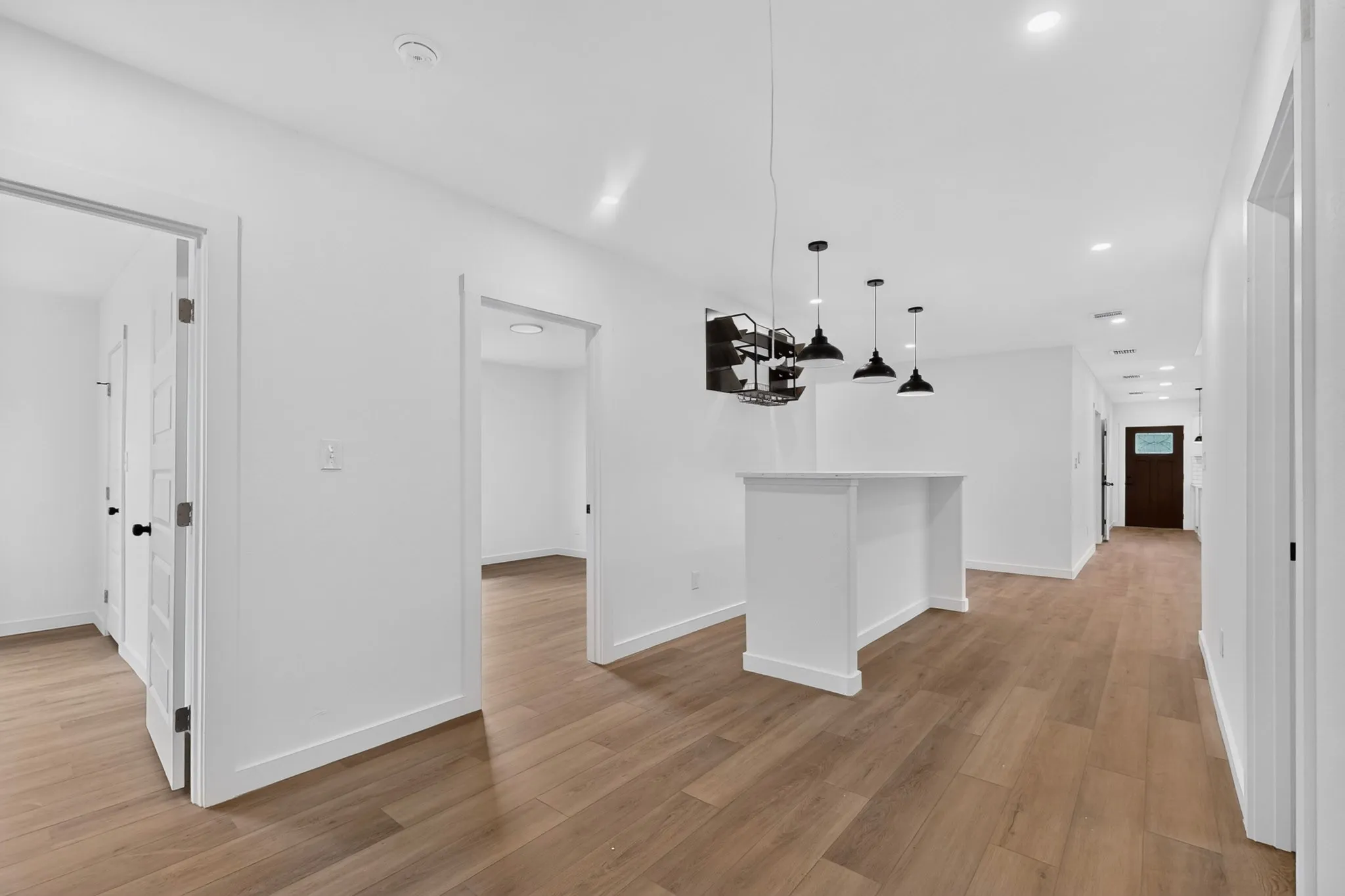 Wood-finish flooring throughout, with recessed lighting and pendant fixtures