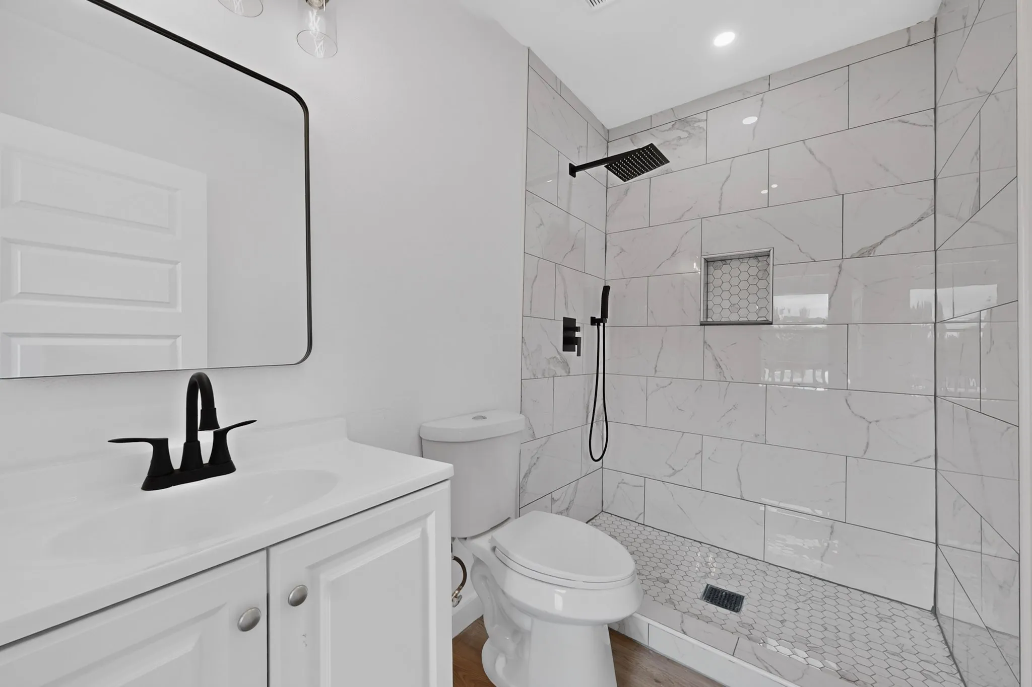 White vanity with matte black faucet and rectangular mirror