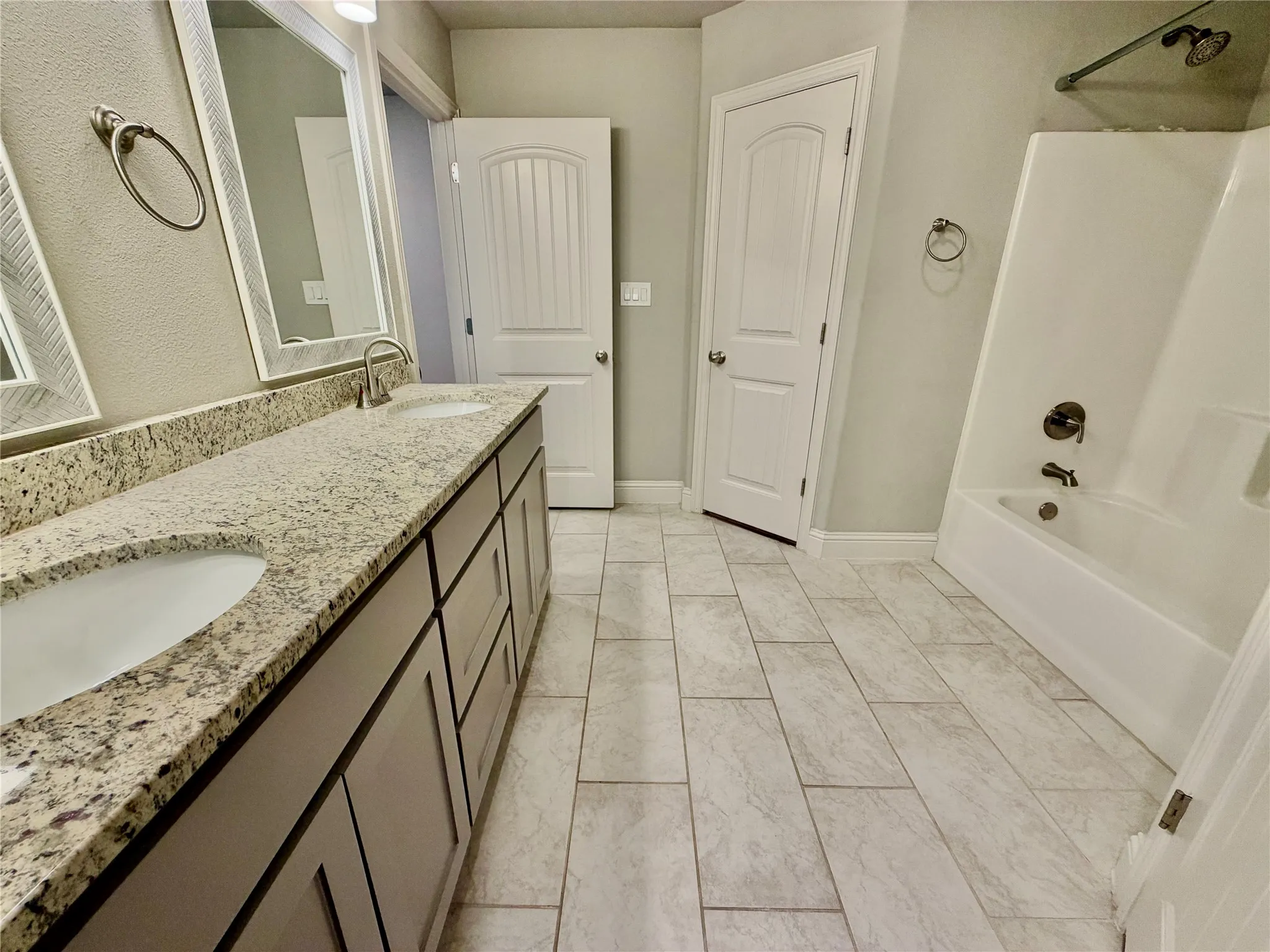 Dual vanity with stone-finish countertop, undermount sinks, and brushed nickel fixtures
