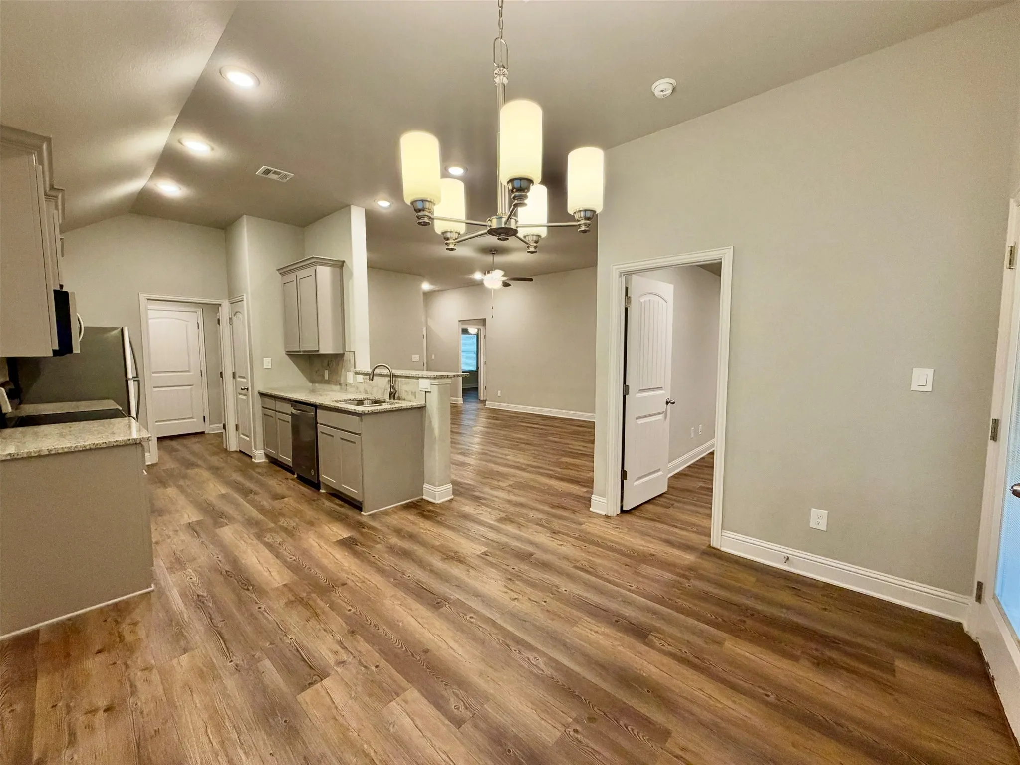 Kitchen area featuring wood-finish flooring, gray cabinetry, and light-toned countertops
