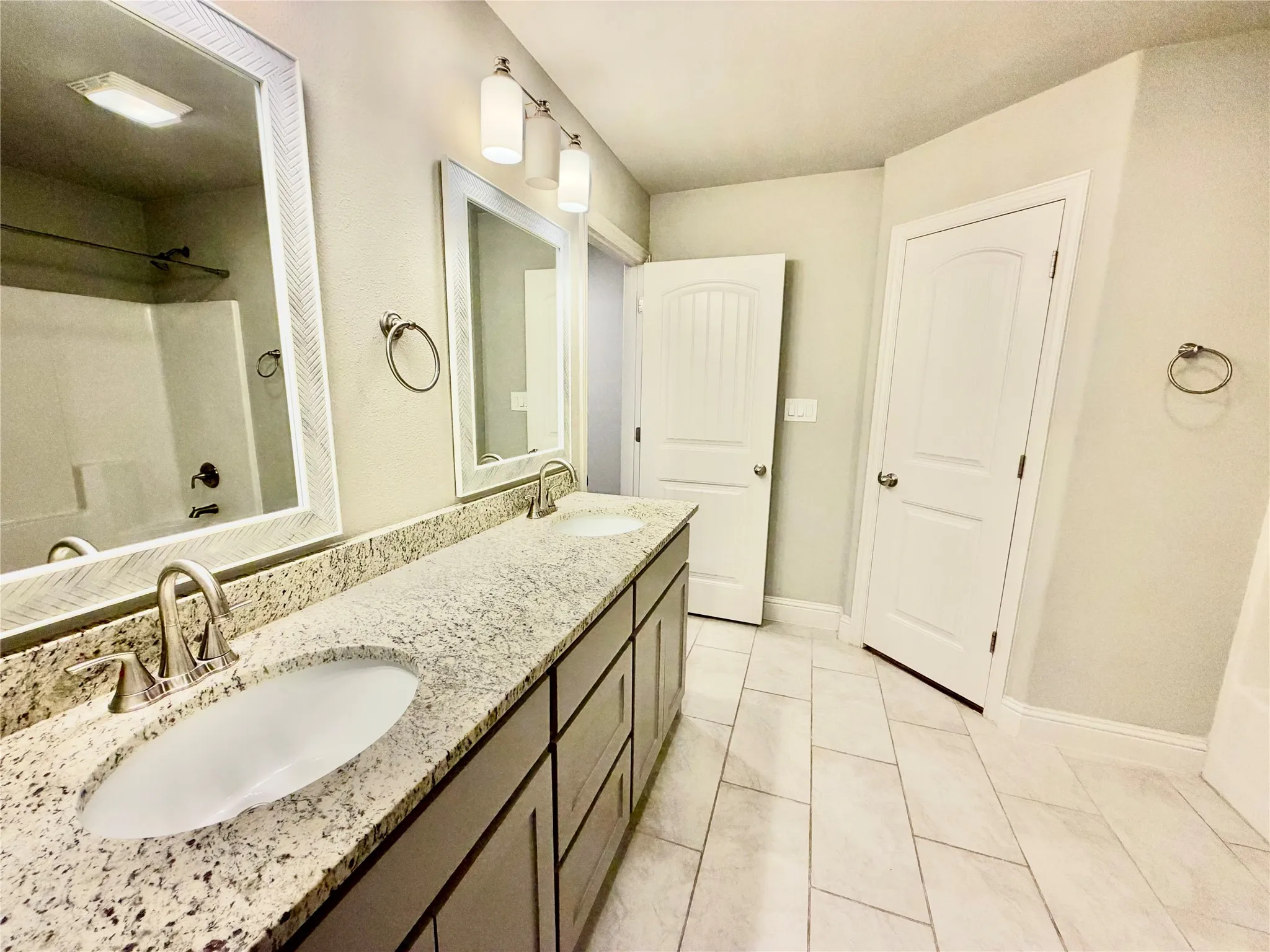 Dual vanity with granite countertops, undermount sinks, and brushed nickel fixtures