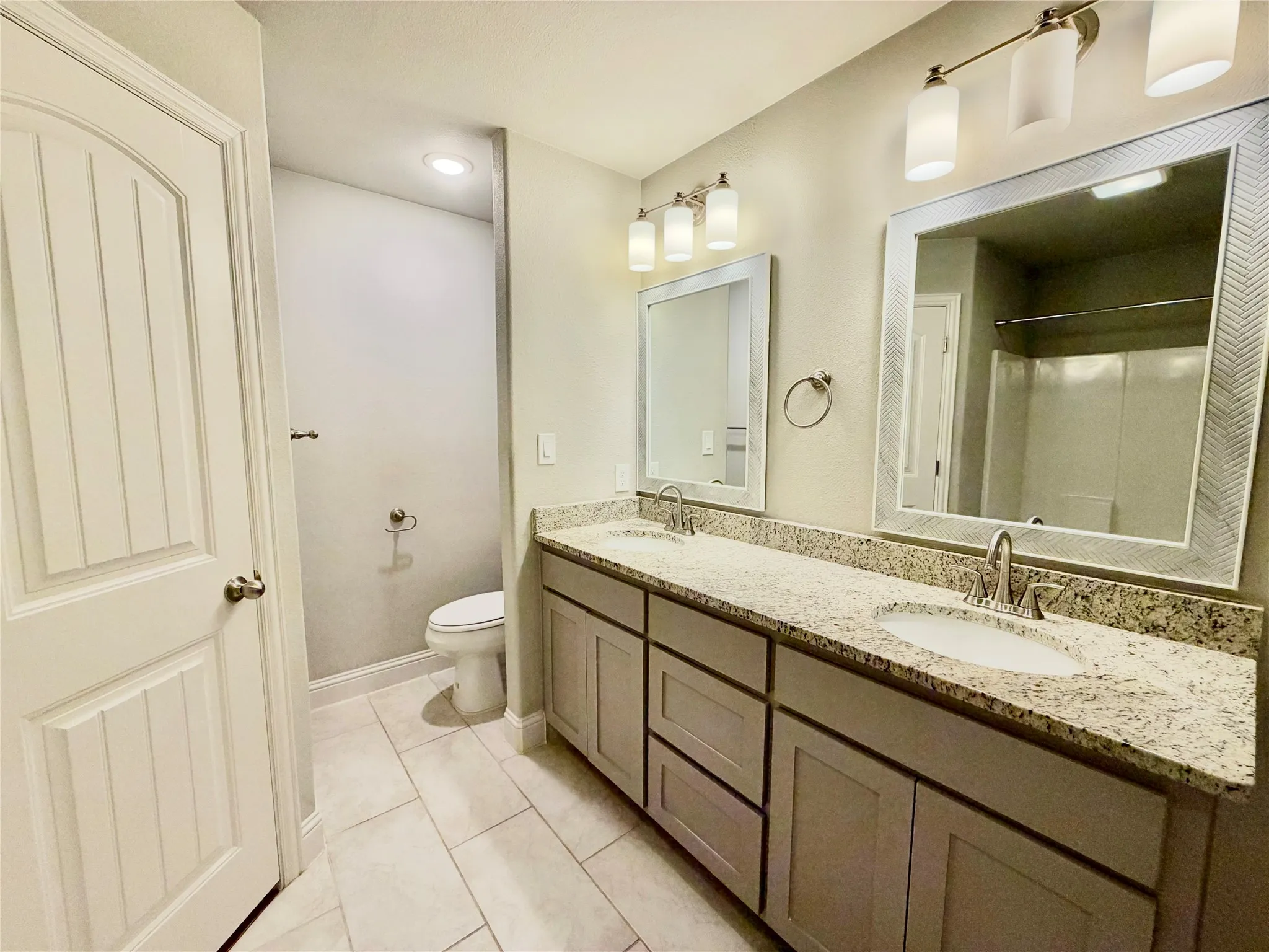 Dual vanity with integrated sinks, speckled countertops, and individual framed mirrors