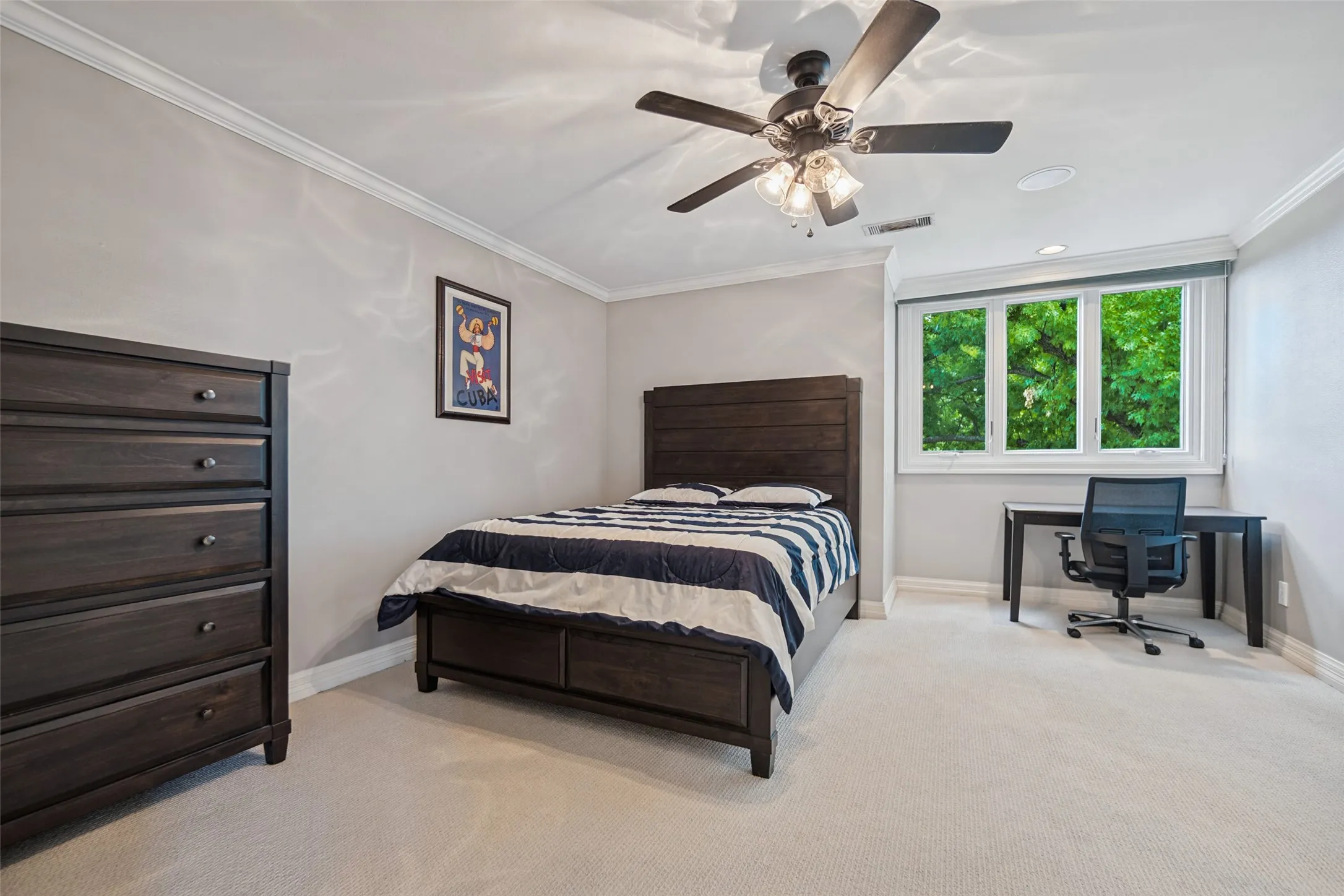 Neutral wall paint, crown molding, ceiling fan with light fixture, light-toned carpet flooring, and a multi-pane window