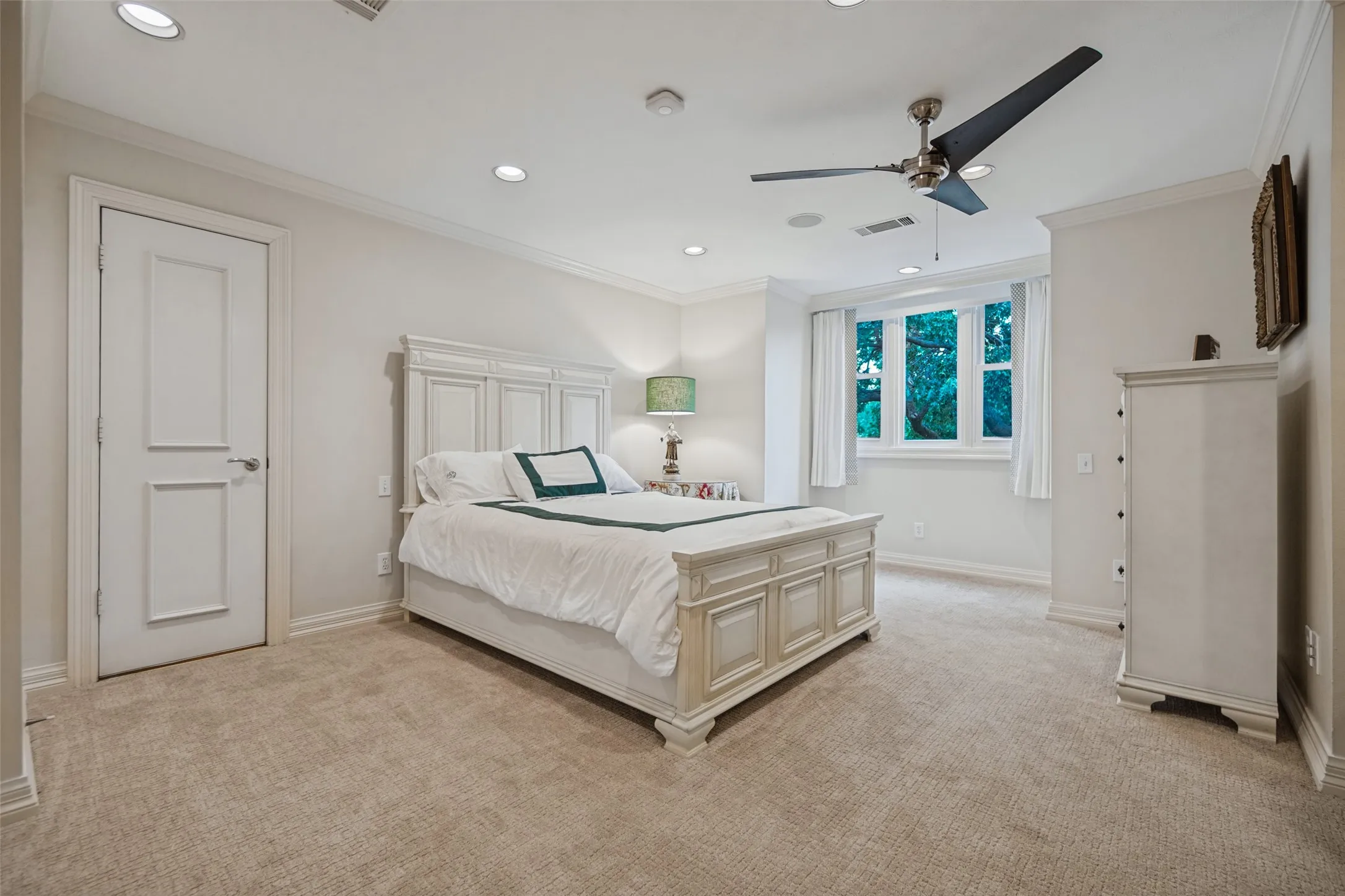 Upstairs primary bedroom with recessed lighting, crown molding, broadloom carpet, multi-pane window, and a ceiling fan with integrated lighting