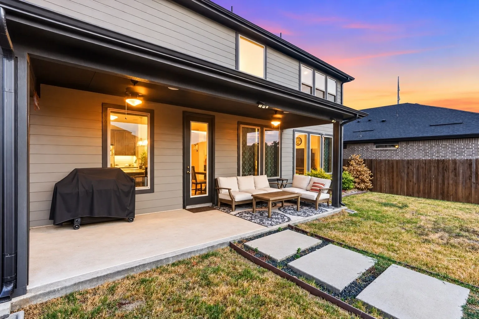 Spacious concrete patio with a covered outdoor living area and recessed lighting
