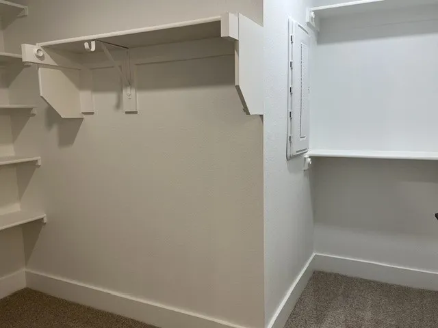 Built-in shelving units with white finishes and a textured wall surface
