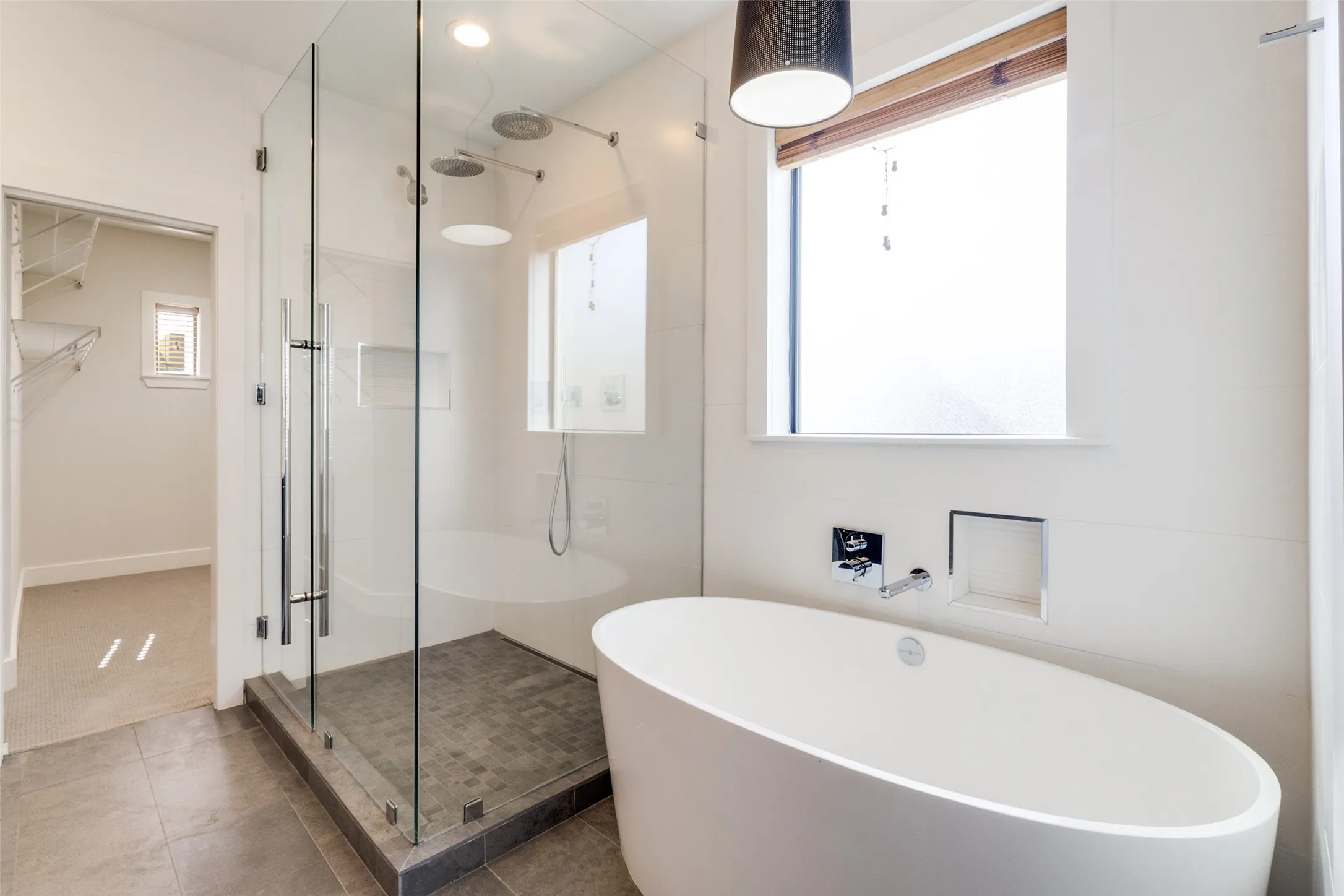 Remodeled Primary Ensuite Bath with volcanic limestone soaking tub, frameless shower with Hansgrohe fixures