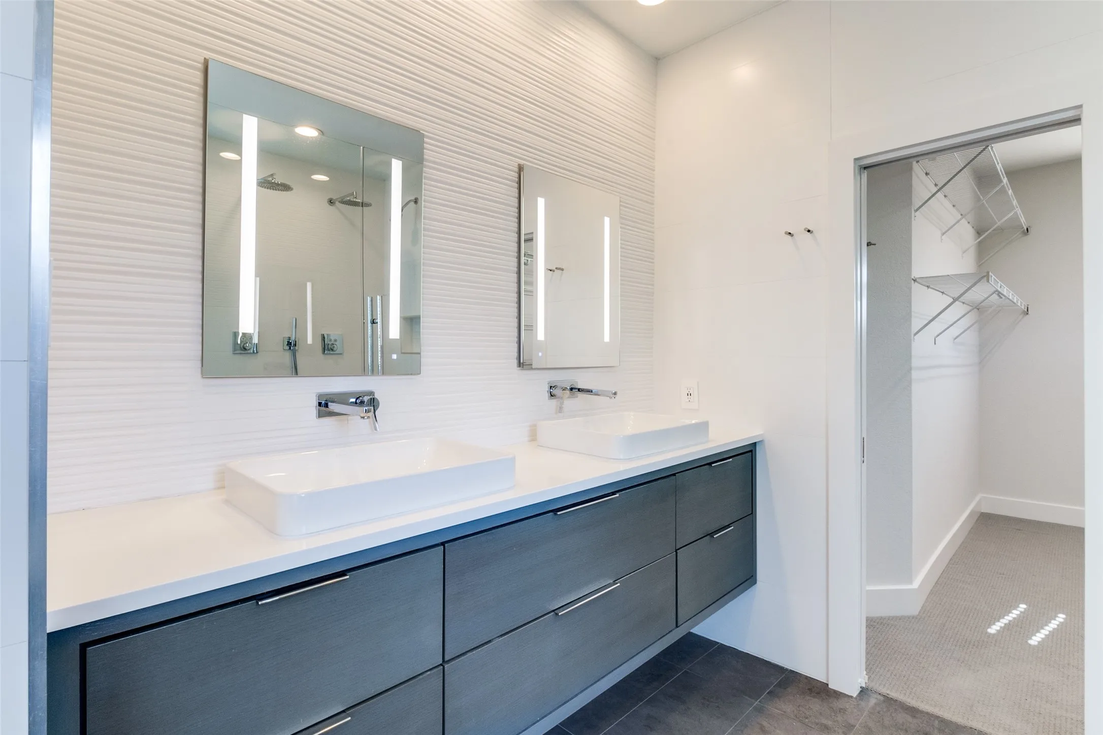 AiO Lighted mirrored medicine cabinet, quartz countertops & Porcelanosa tile throughout the bath