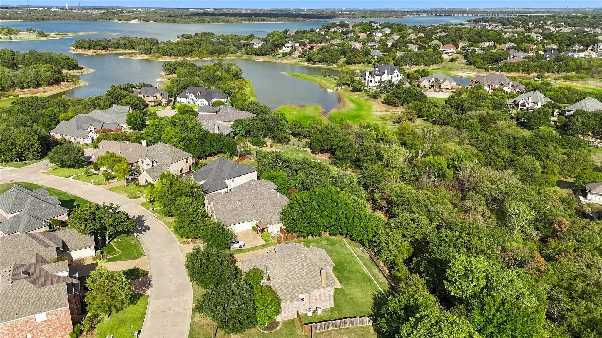Aerial perspective showcasing mature tree canopy, waterfront access, and residential lots