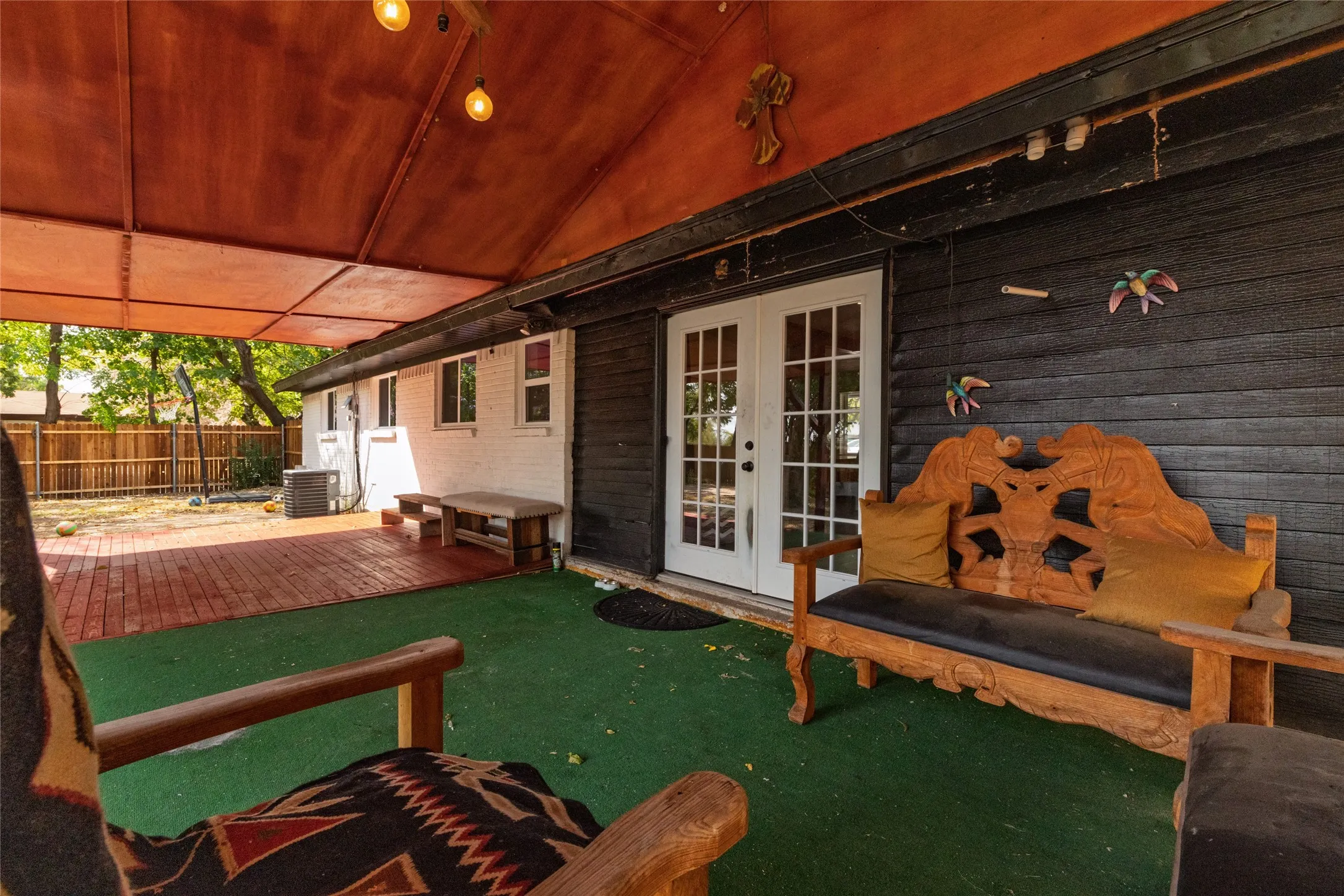 Covered patio area with green-finish flooring and a red-toned plank deck