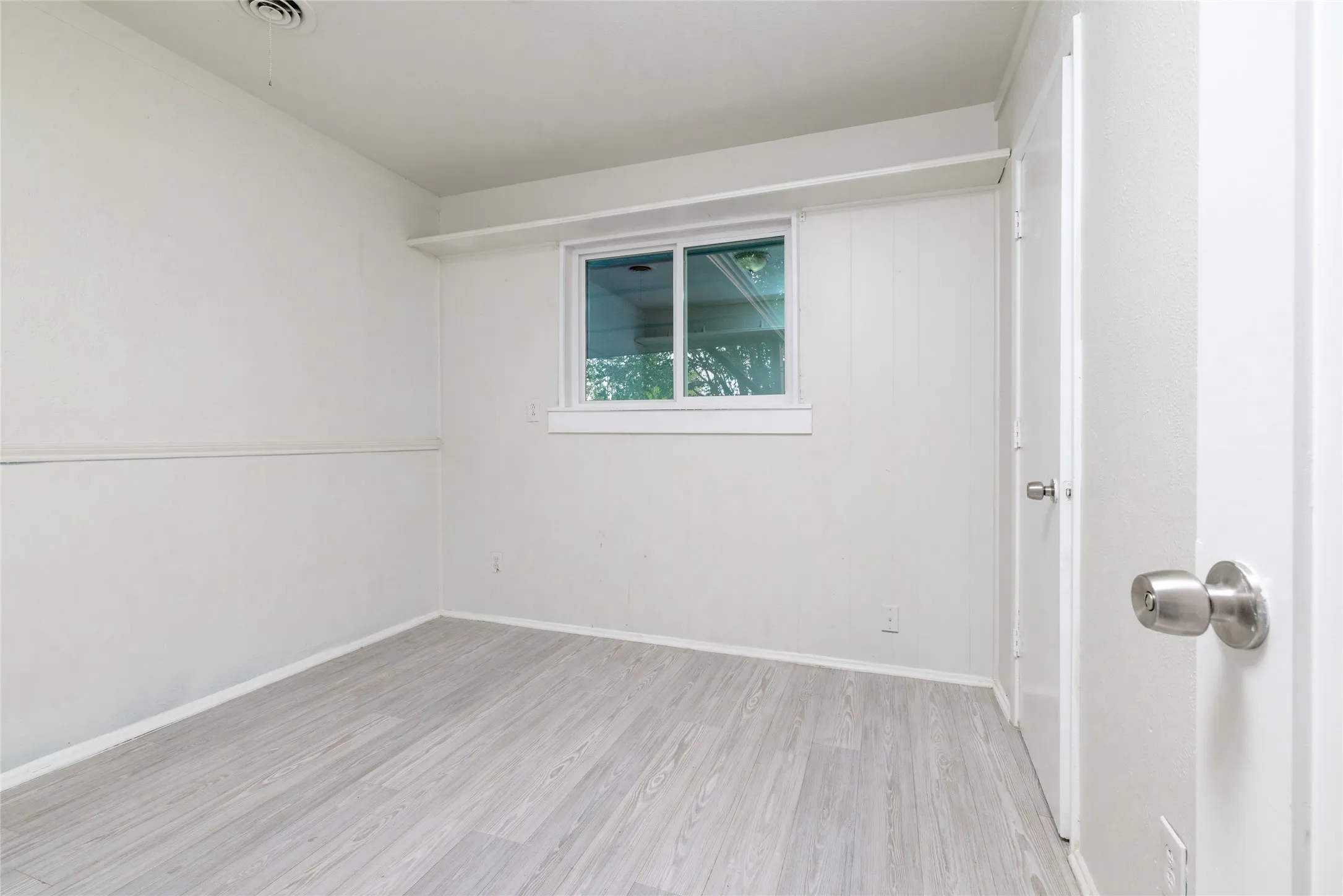 Wood-finish flooring with white walls and trim