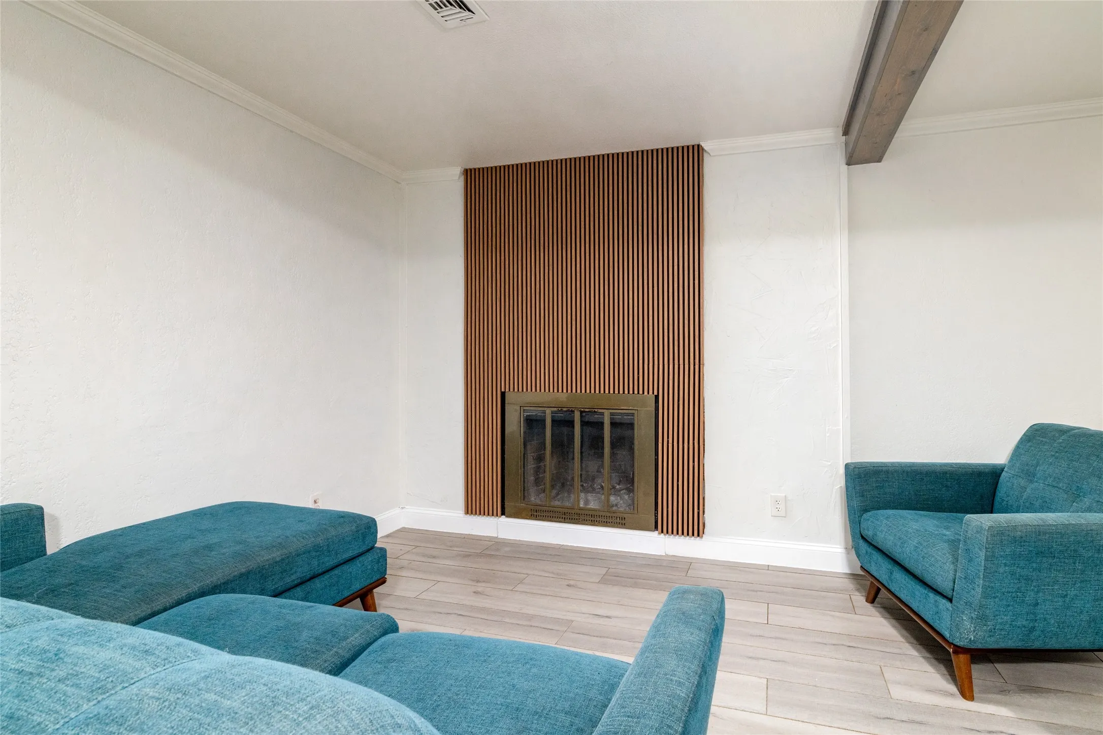 Fireplace with a wood-slat surround and brass-tone insert