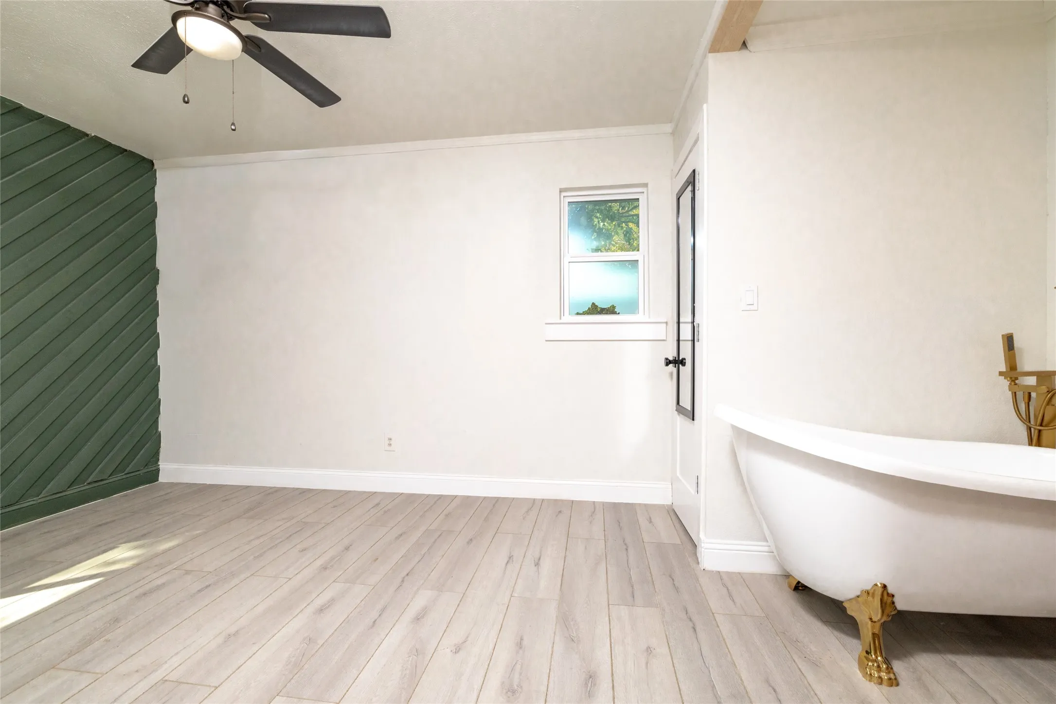 Light wood-finish flooring with a decorative green accent wall