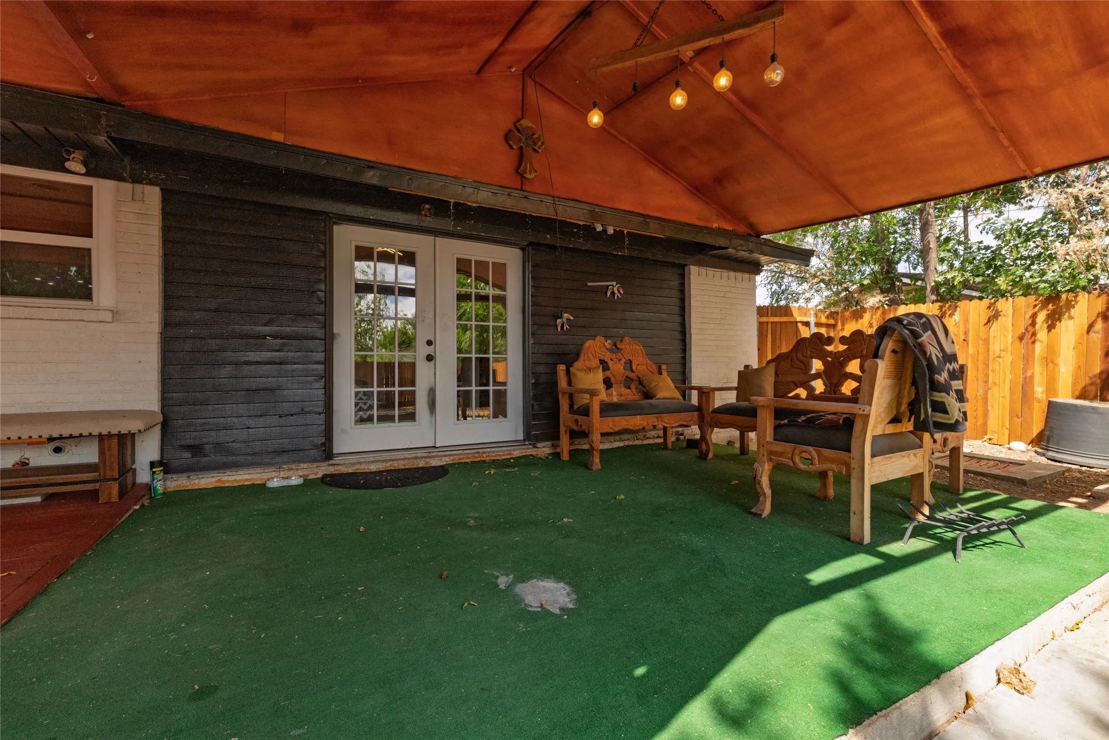 Covered patio with an artificial turf surface and exposed beam ceiling