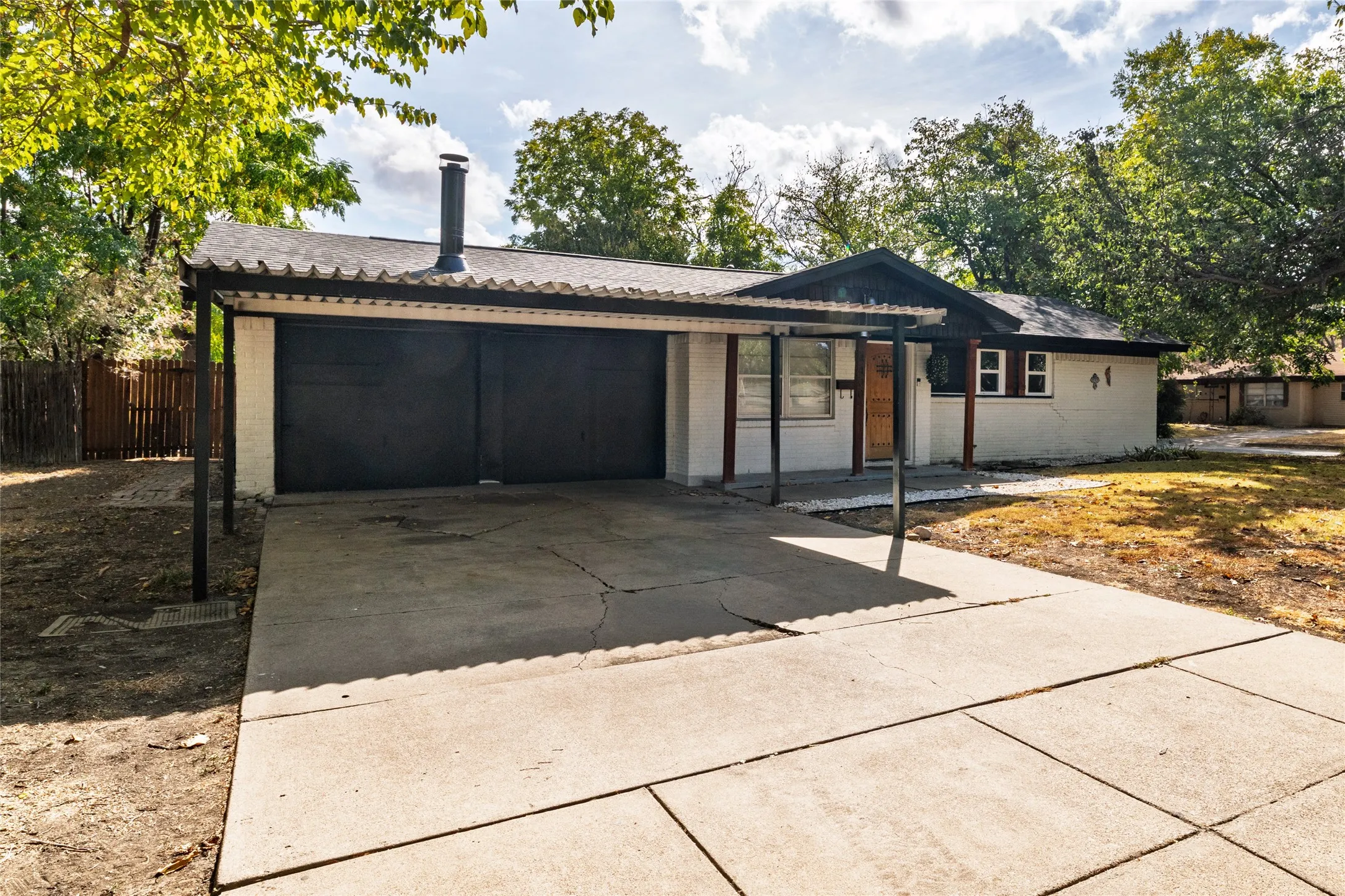 Single-story residence featuring a covered carport, two-car garage, and a concrete driveway