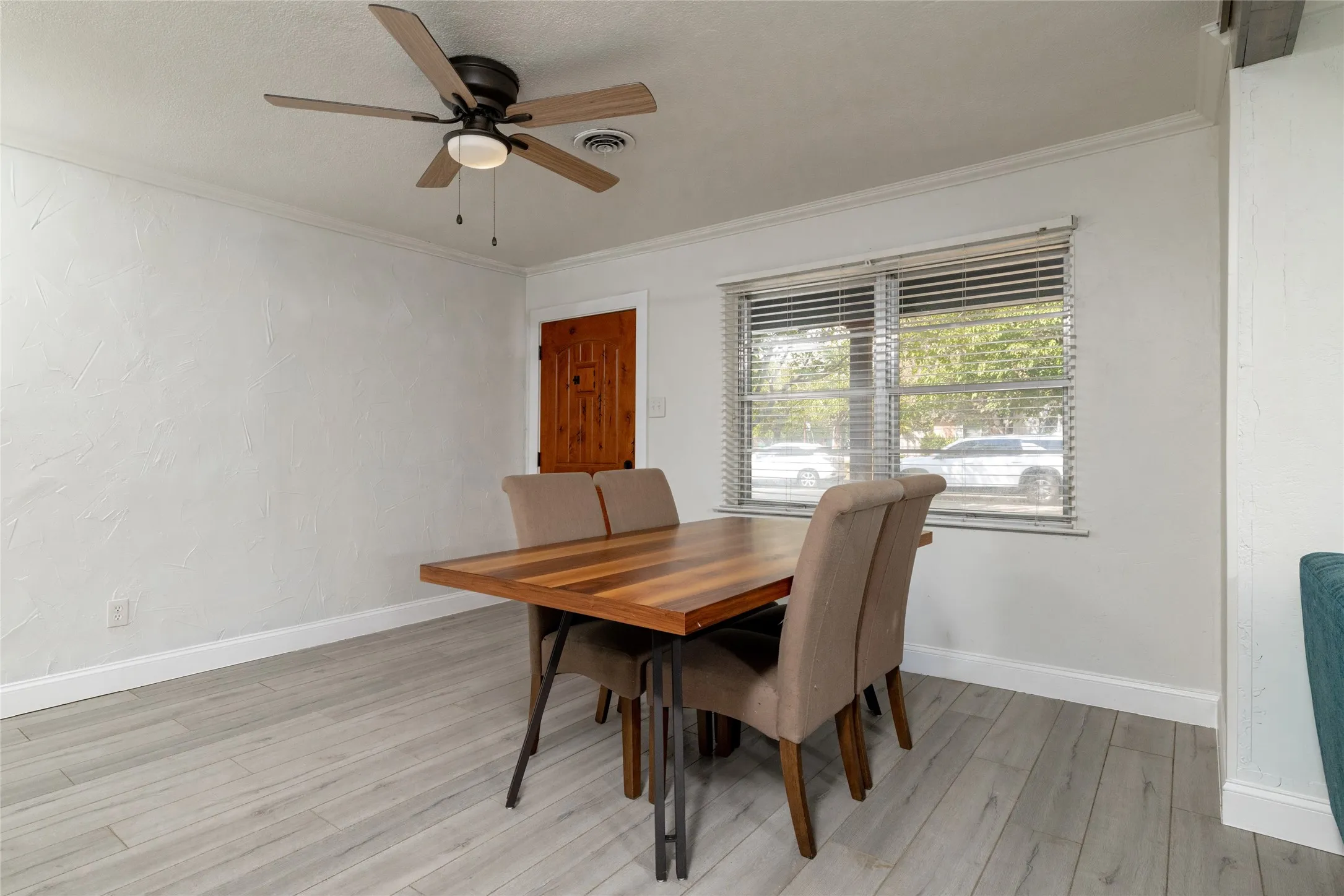 Ceiling fan with integrated lighting, wood-finish flooring, textured wall finish, and a window with blinds